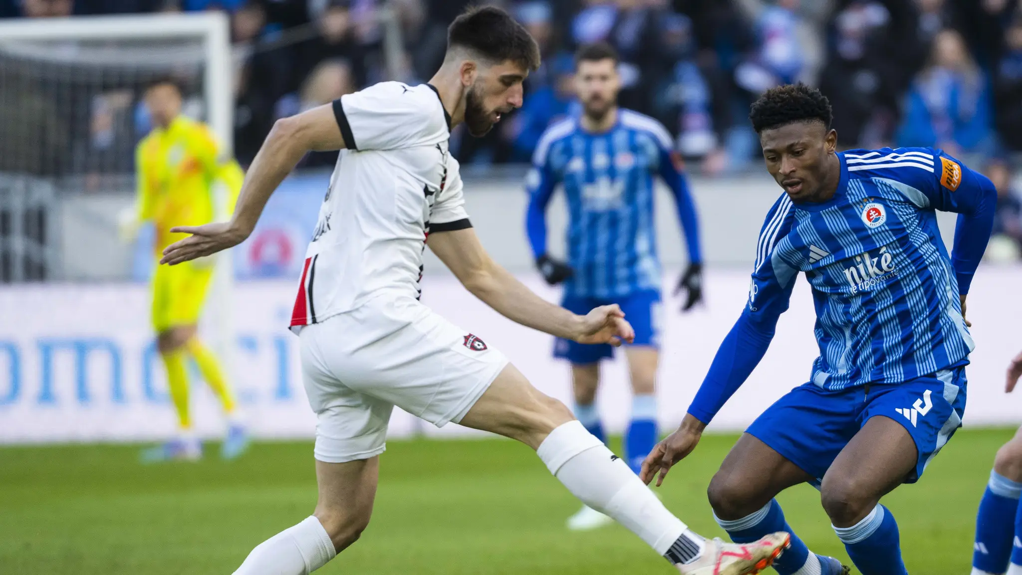 Adrian Zeljkovič (v bielom) proti Slovanu Bratislava. V pozadí aj Kenan Bajrič.