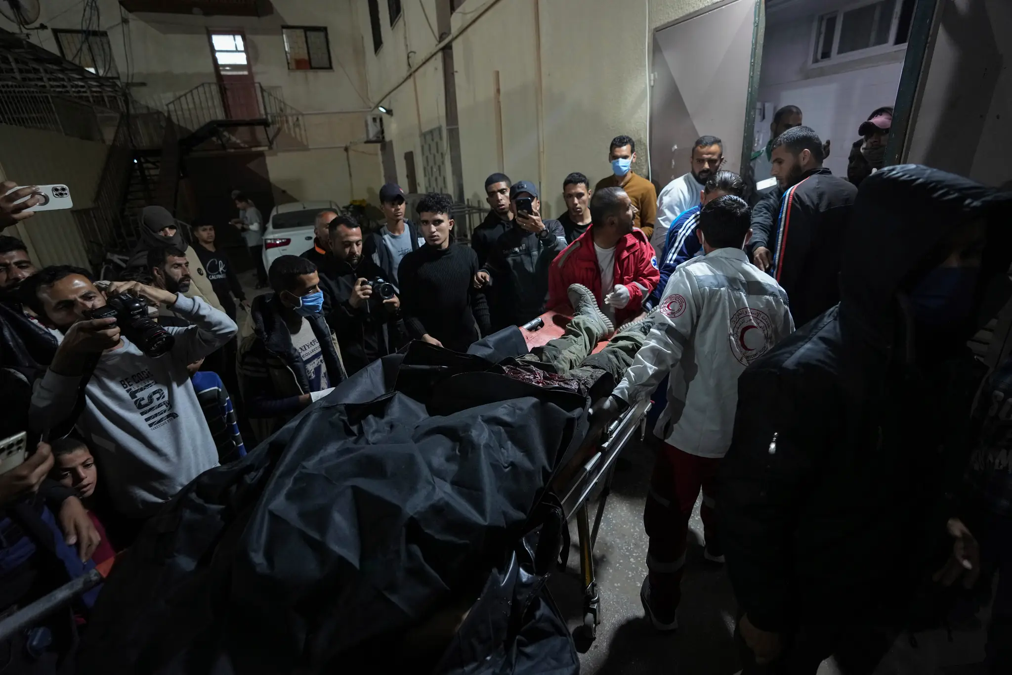 Palestínčania prinášajú telo obete, ktorá prišla o život pri leteckom útoku izraelskej armády, do nemocnice.