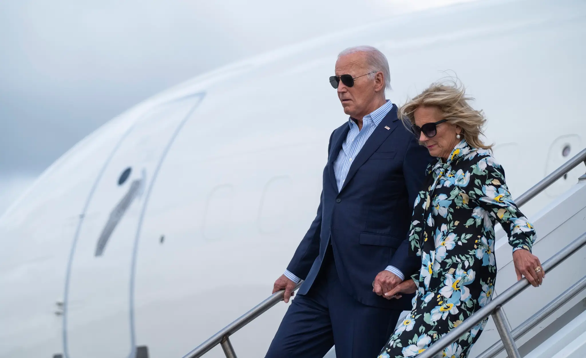Prezident USA Joe Biden s manželkou Jill vystupujú z lietadla.
