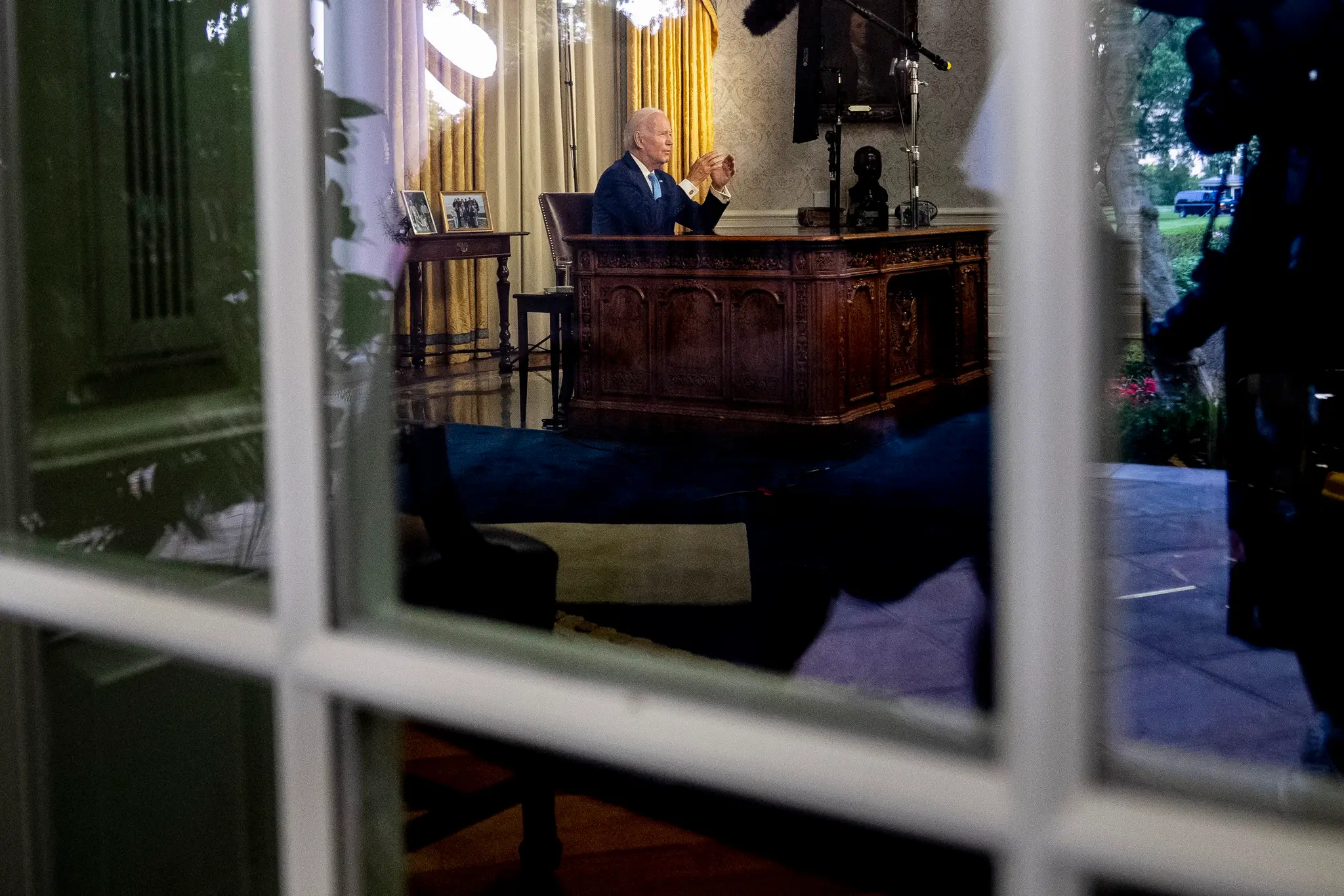 Joe Biden sedi za stolom vo svojej pracovnice v Bielom dome.