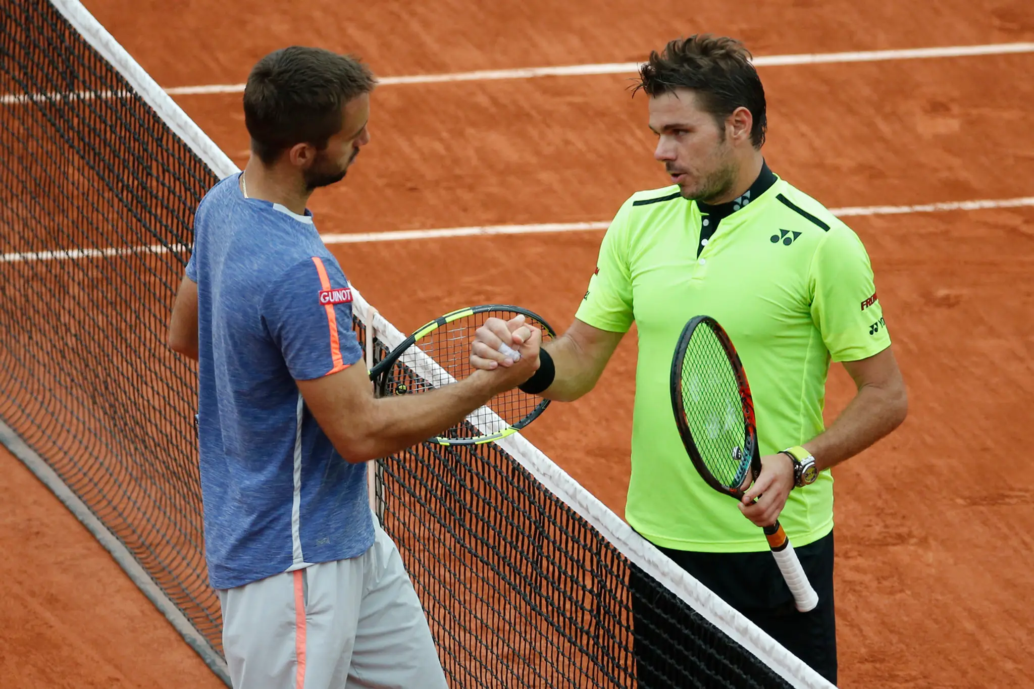 Obhajca trofeje Švajčiar Stan Wawrinka (vpravo) a Srb Viktor Troicki si podávajú ruky po osemfinále na Roland Garros.