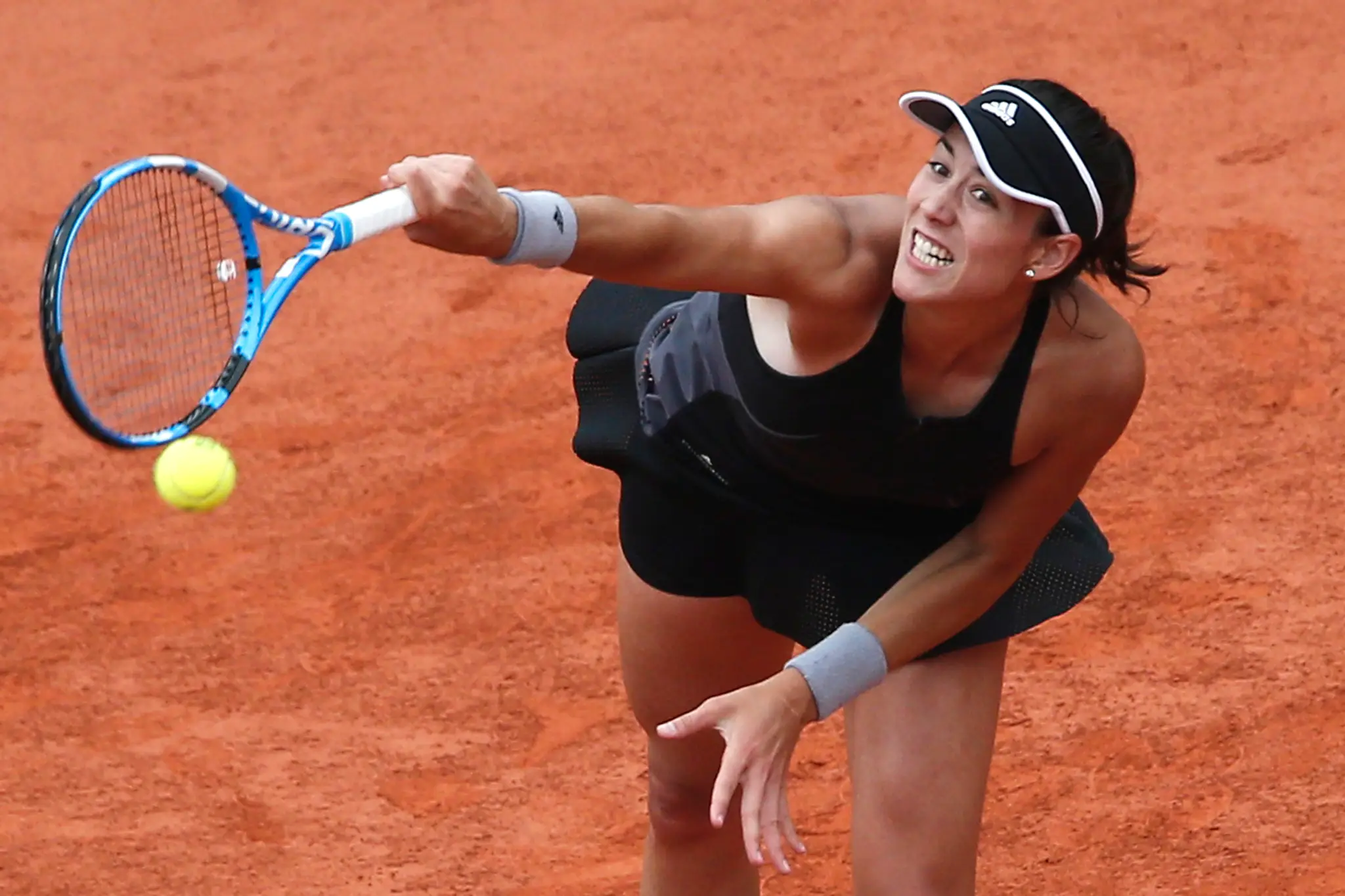 Garbine Muguruzová podáva vo štvrťfinále dvojhry proti Marii Šarapovovej na grandslamovom turnaji Roland Garros.