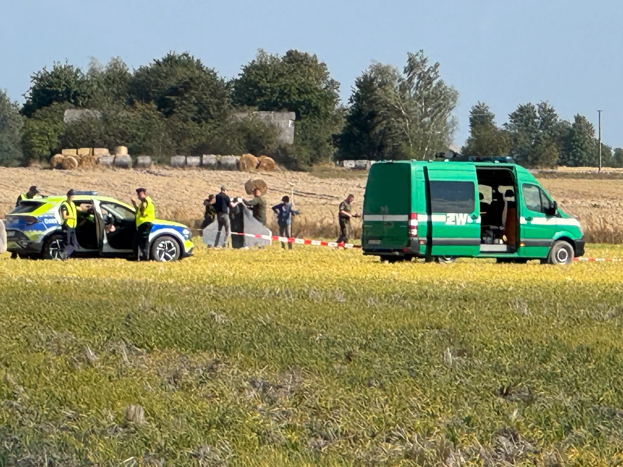 Policajti a príslušníci vojenskej polície zabezpečujú časť úlomkov jedného z dronov, ktoré narušili vzdušný priestor Poľska.