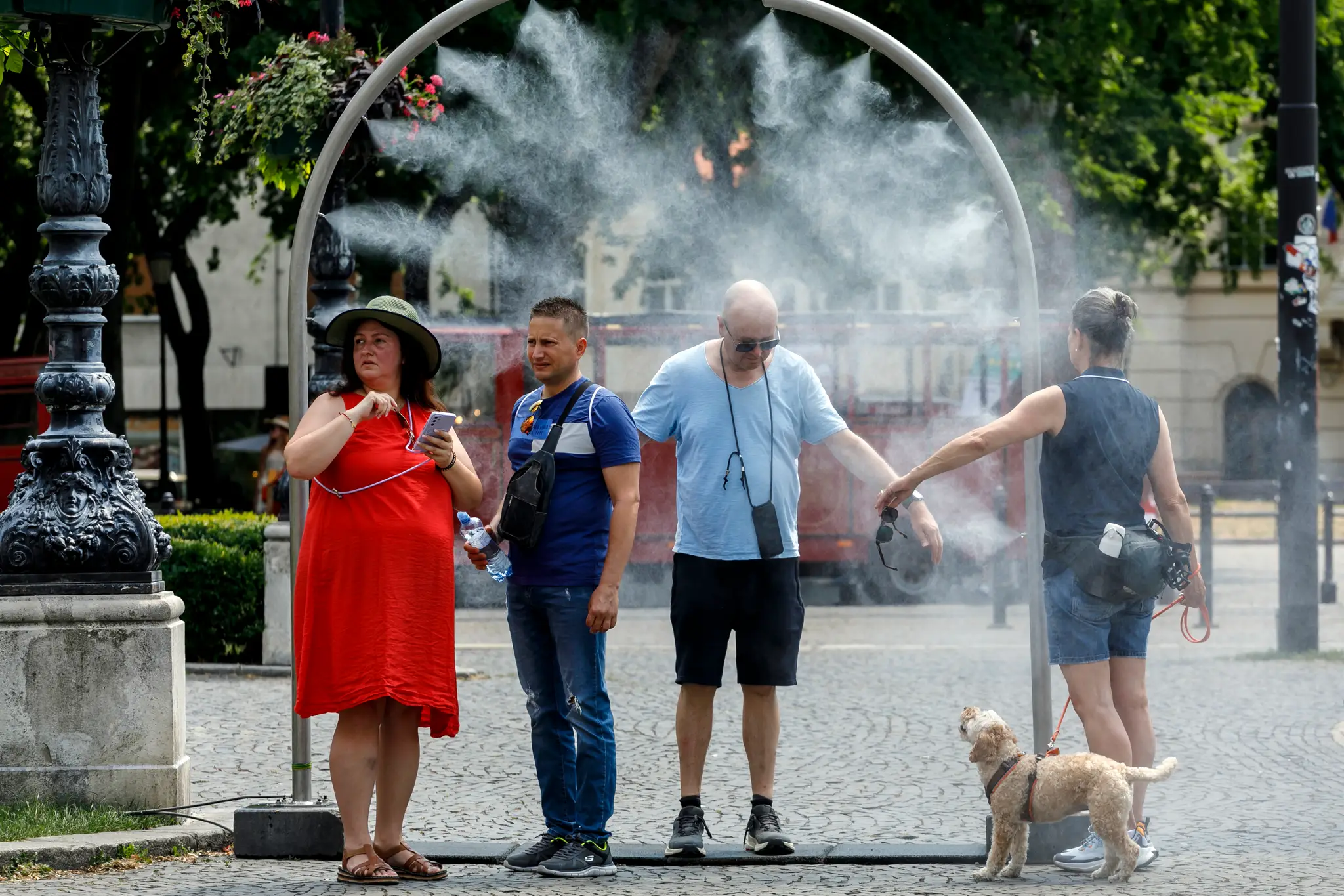 Na snímke ľudia sa ochladzujú v osviežovači počas vysokých teplôt na Hviezdoslavovom námestí v mestskej časti Bratislava - Staré mesto.