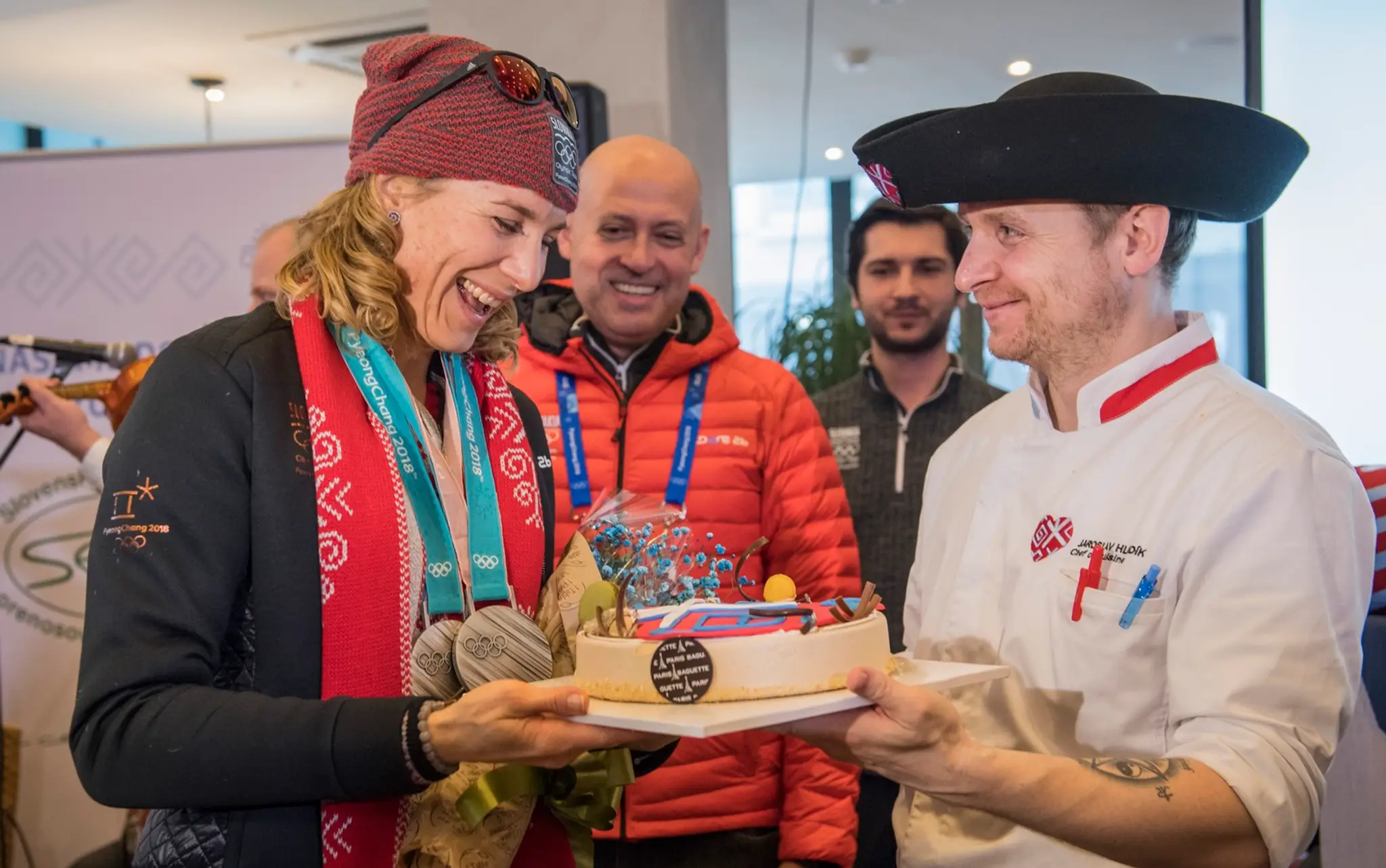 Anastasia Kuzminová si preberá tortu, uprostred prezident SOV Anton Siekel v Slovenskom dome počas ZOH v Pjongčangu.