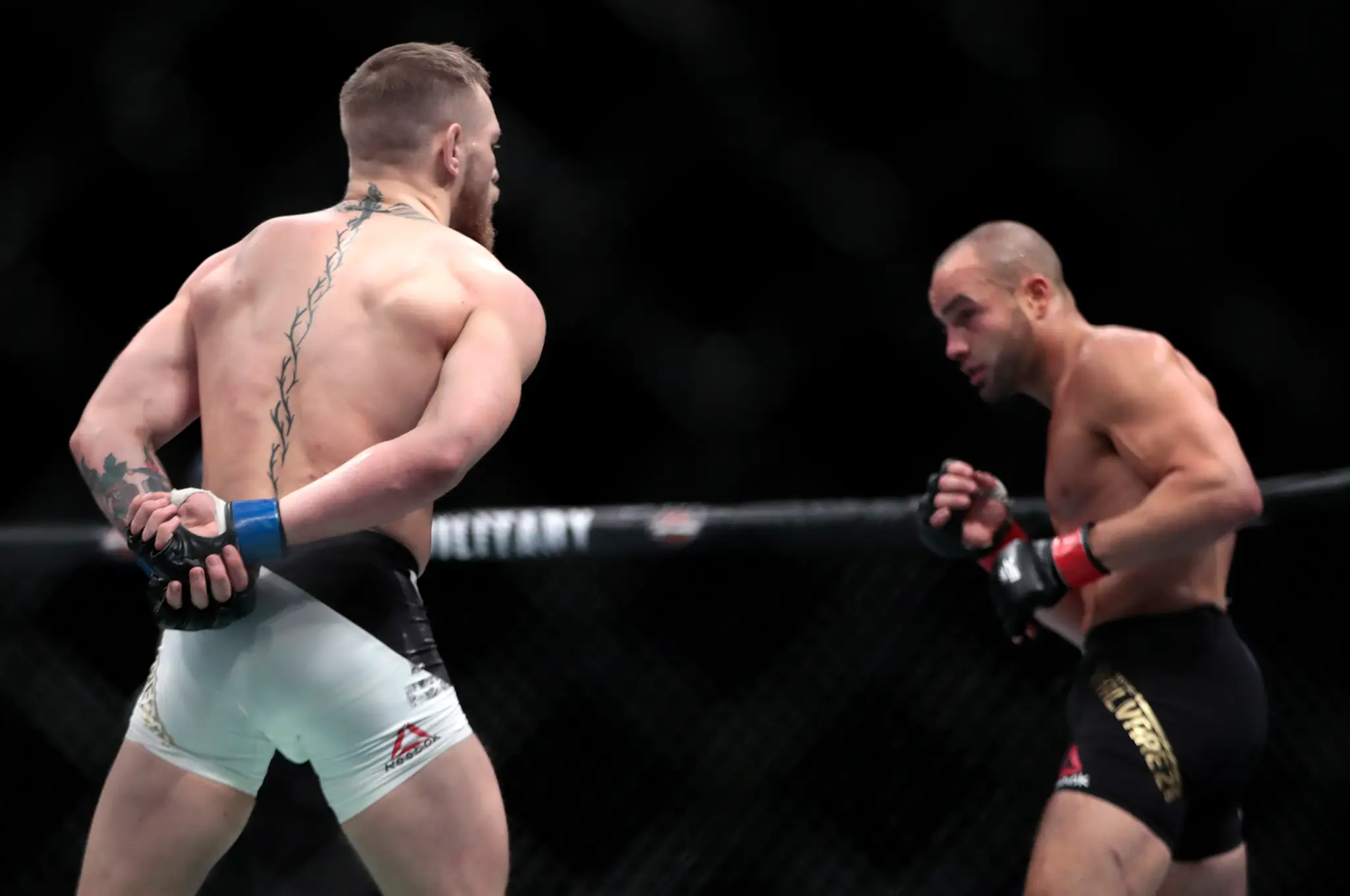 Conor McGregor sa gestom rukami za chrbtom vysmieva protivníkovi Eddiemu Alvarezovi.