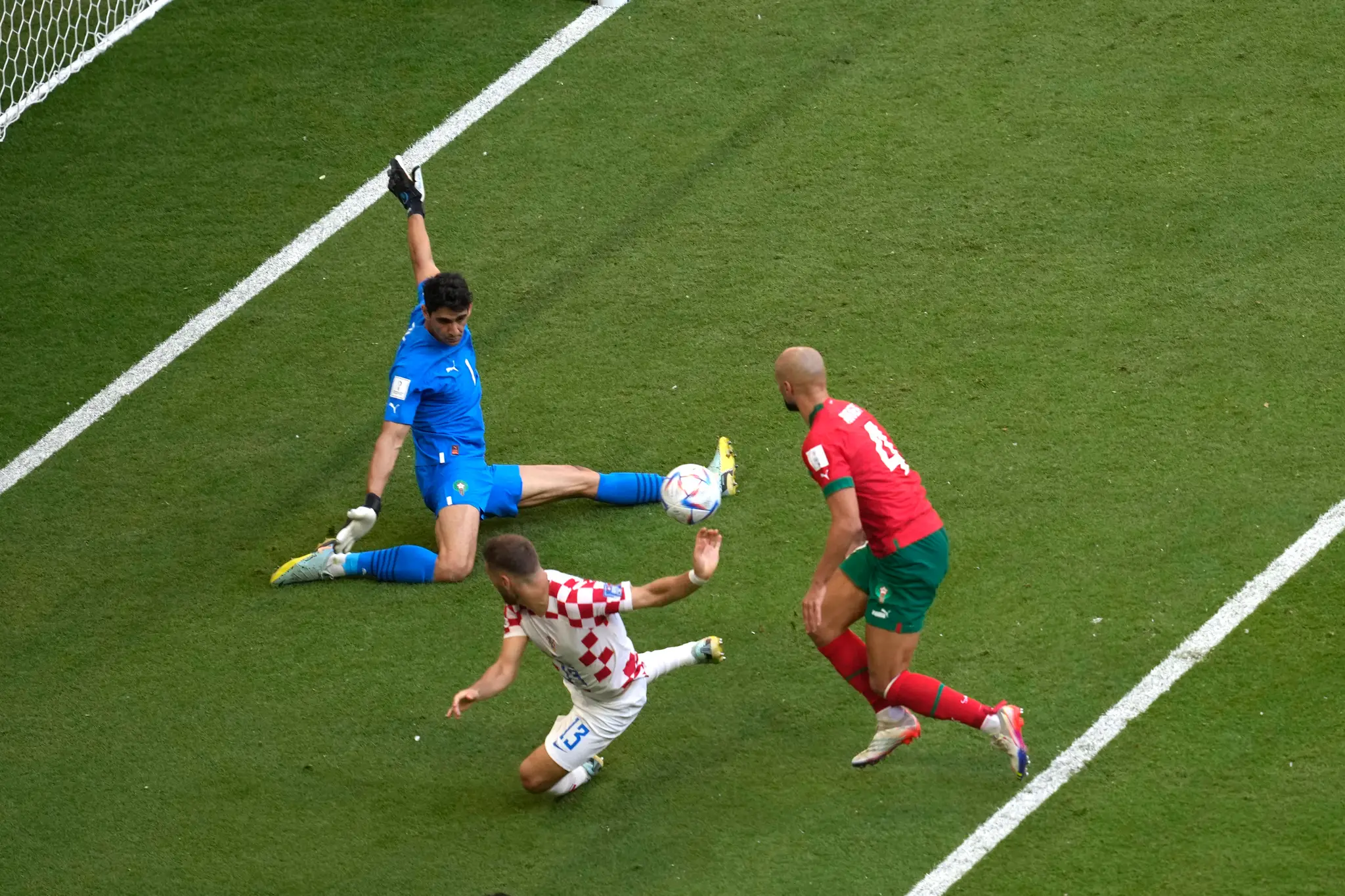 Marocký brankár Yassine Bounou chytá loptu pred Chorvátom Nikolom Vlašičom na MS 2022.