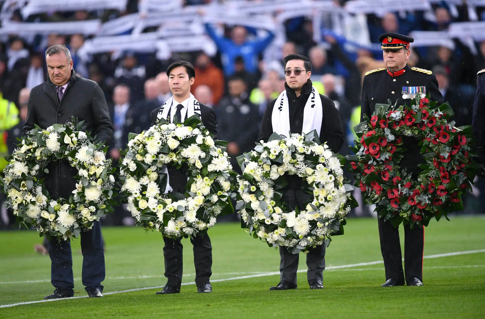Aiyawatt Srivaddhanaprabha (druhý sprava) pokladá veniec na pamiatku zosnulého otca a majiteľa Leicesteru Vičaja Srivaddhanaprab