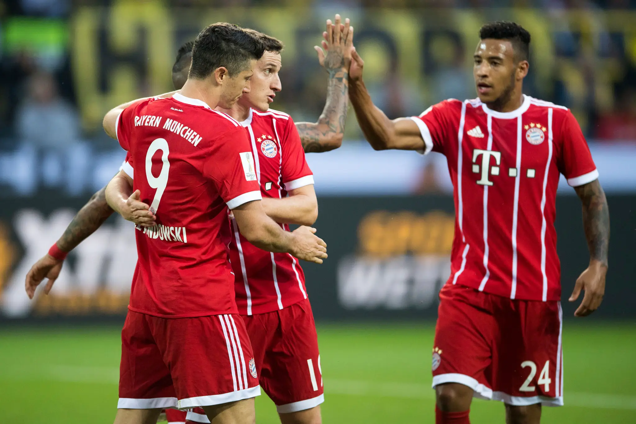 Hráč Bayernu Mníchov Robert Lewandowski (vľavo) s teší z gólu so spoluhráčmi Sebastianom Rudym (uprostred) a Corentim Tolissom 
