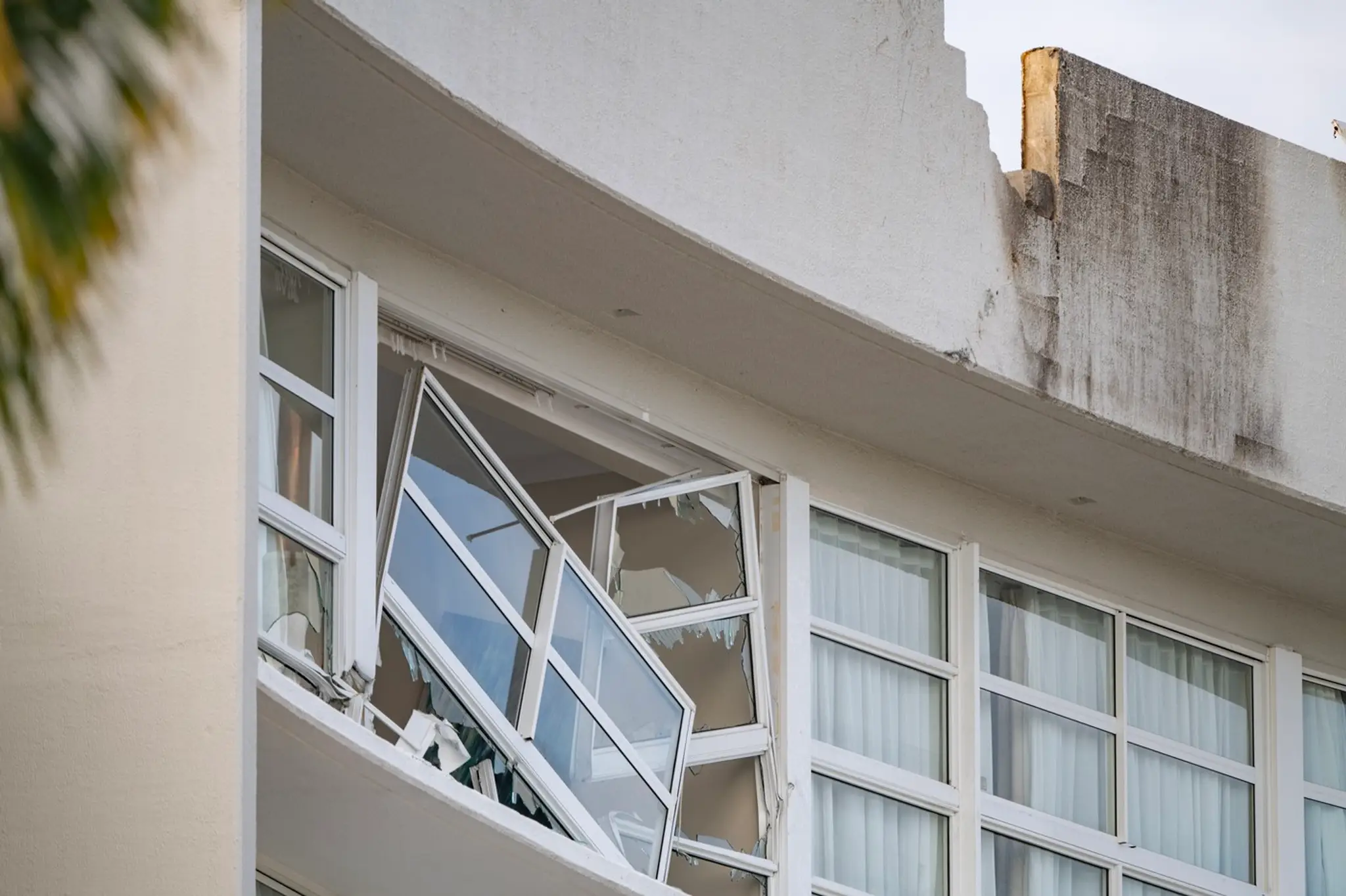 Zničená strecha a okno po páde vrtuľníka na austrálsky hotel Double Tree v meste Cairns.