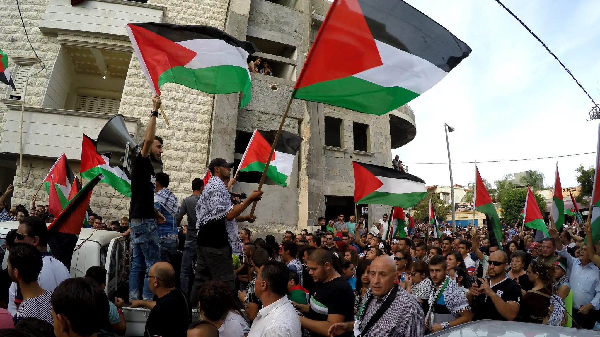Ľudia s vlajkami Palestíny. 