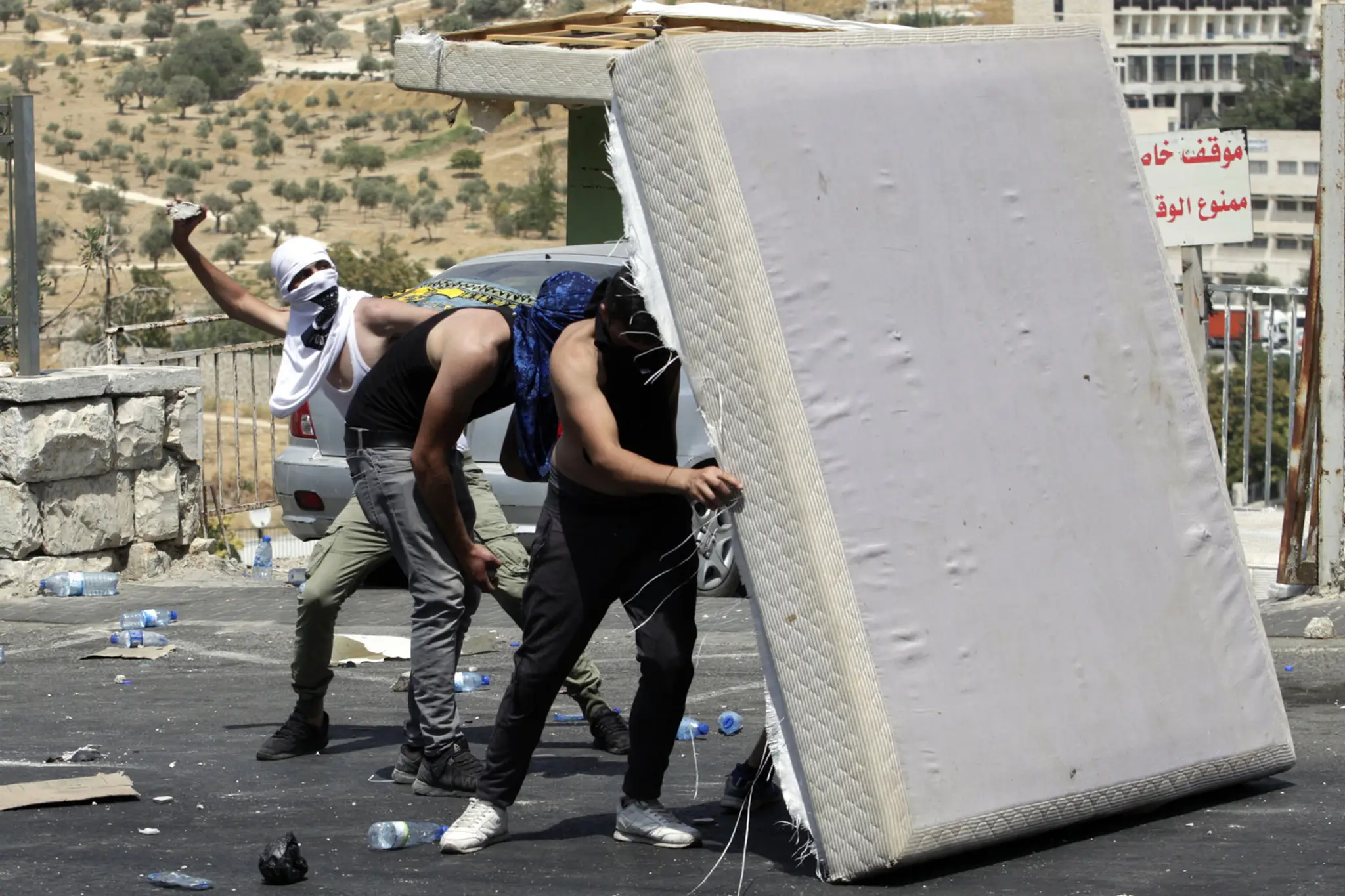 Palestínčania hádžu kamene na izraelskch policajtov.
