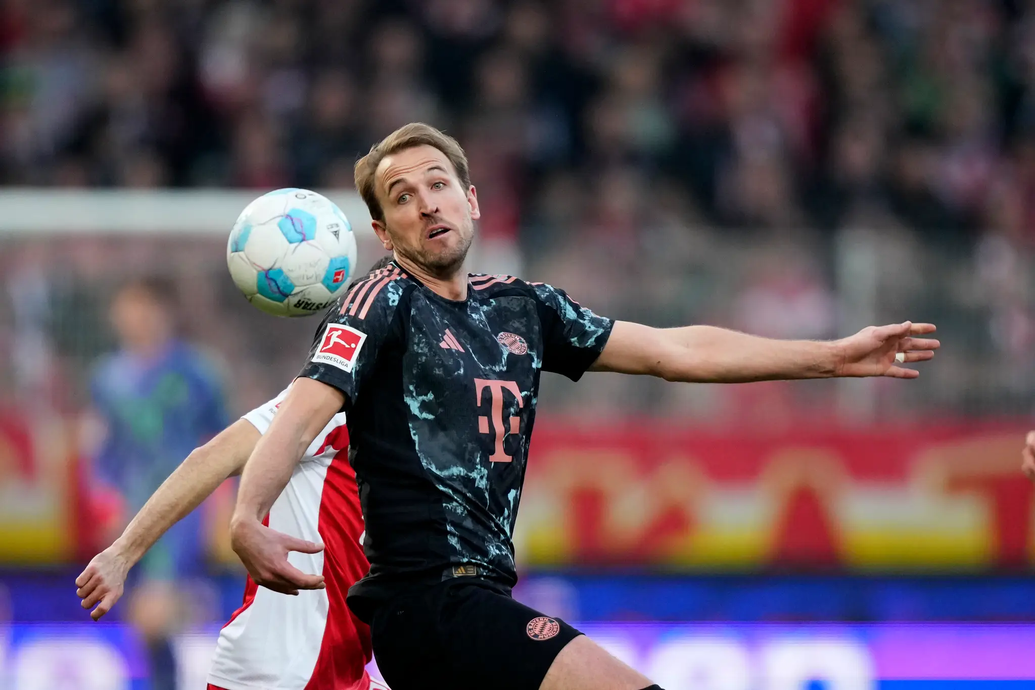 Hráč Bayernu Harry Kane (vpredu) bojuje o loptu.