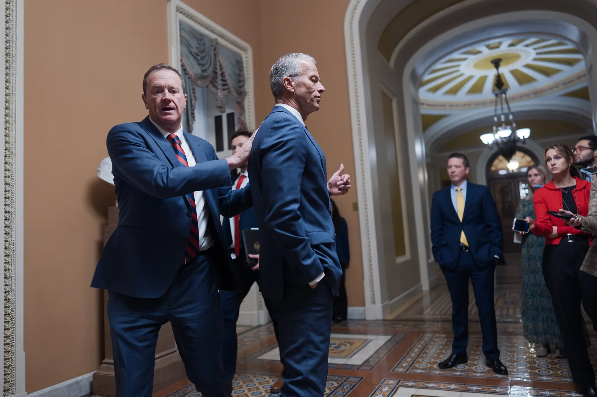 Senátor Eric Schmitt (vľavo)blahoželá predsedovi Senátu Johnovi Thuneovi po konečnom schválení Senátom dočasného zákona o financovaní na obnovenie činnosti vlády.