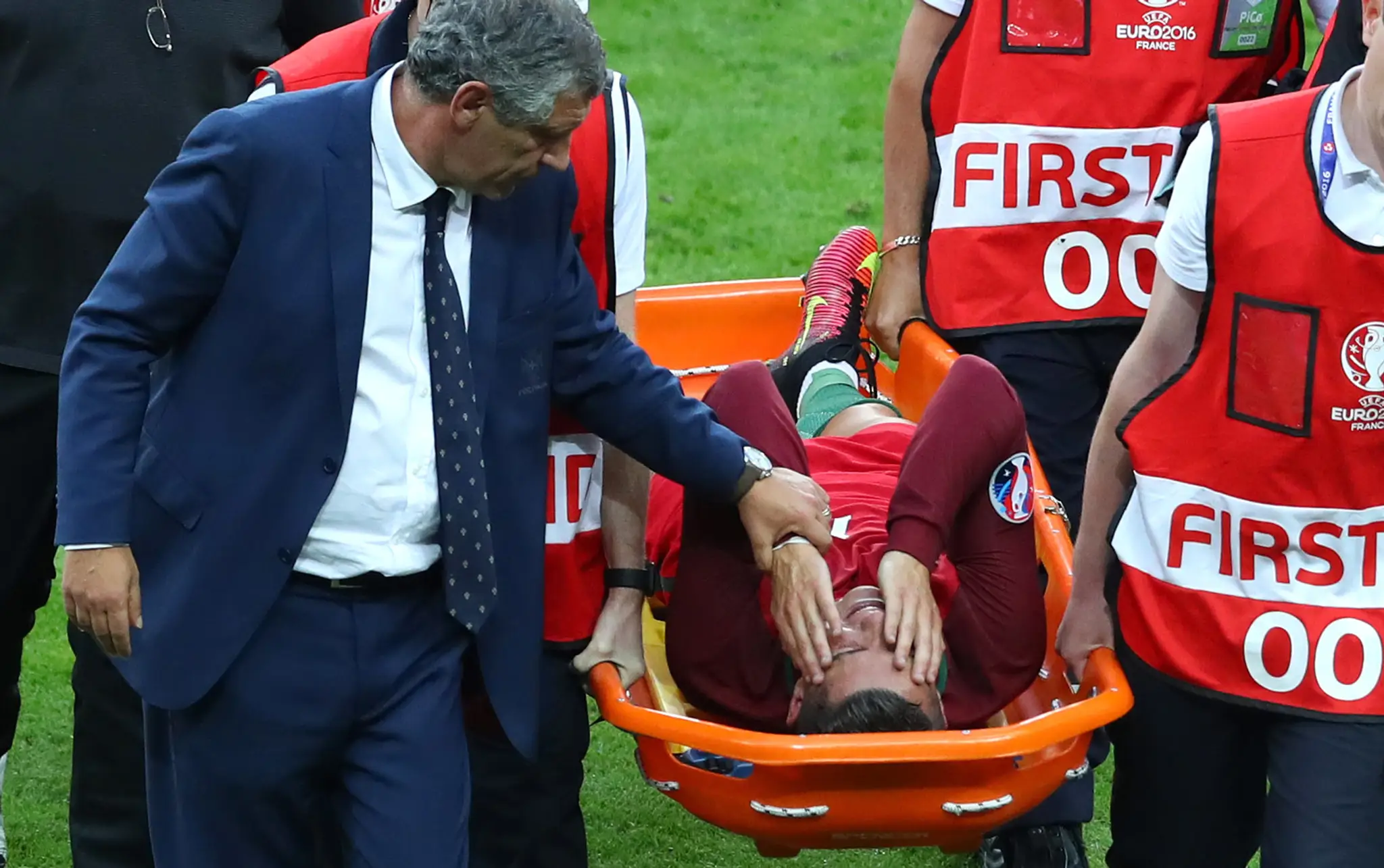 Tréner Portugalska Fernando Santos upokojuje svojho zraneného hráča Cristiana Ronalda.