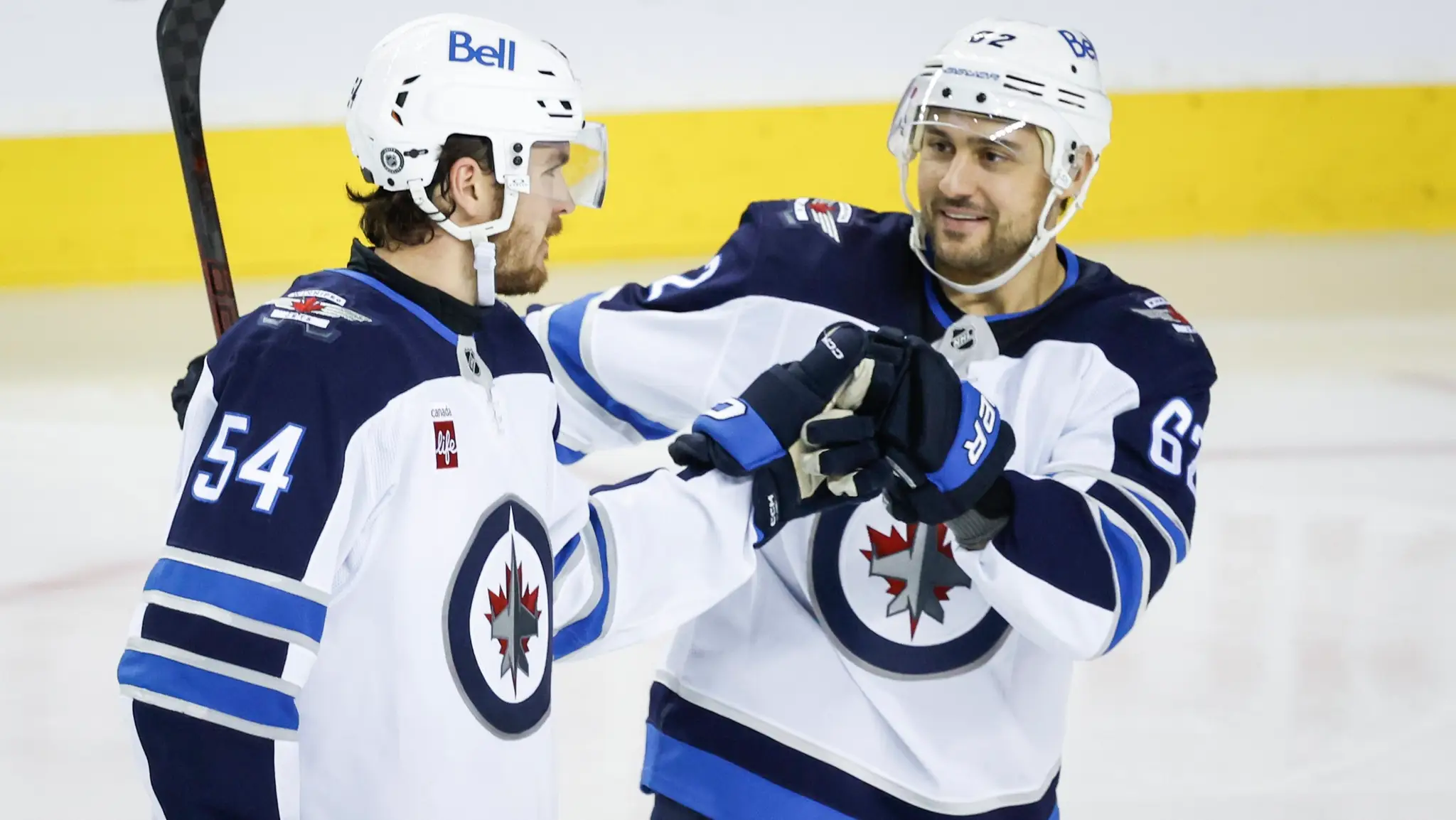Dylan Samberg a Nino Niederreiter sa radujú po góle do siete Calgary Flames.