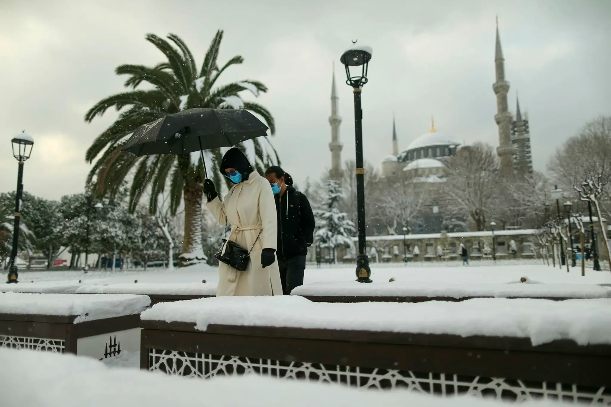 Ľudia kráčajú ulicami Istanbulu počas sneženia v pondelok 24. januára 2022.