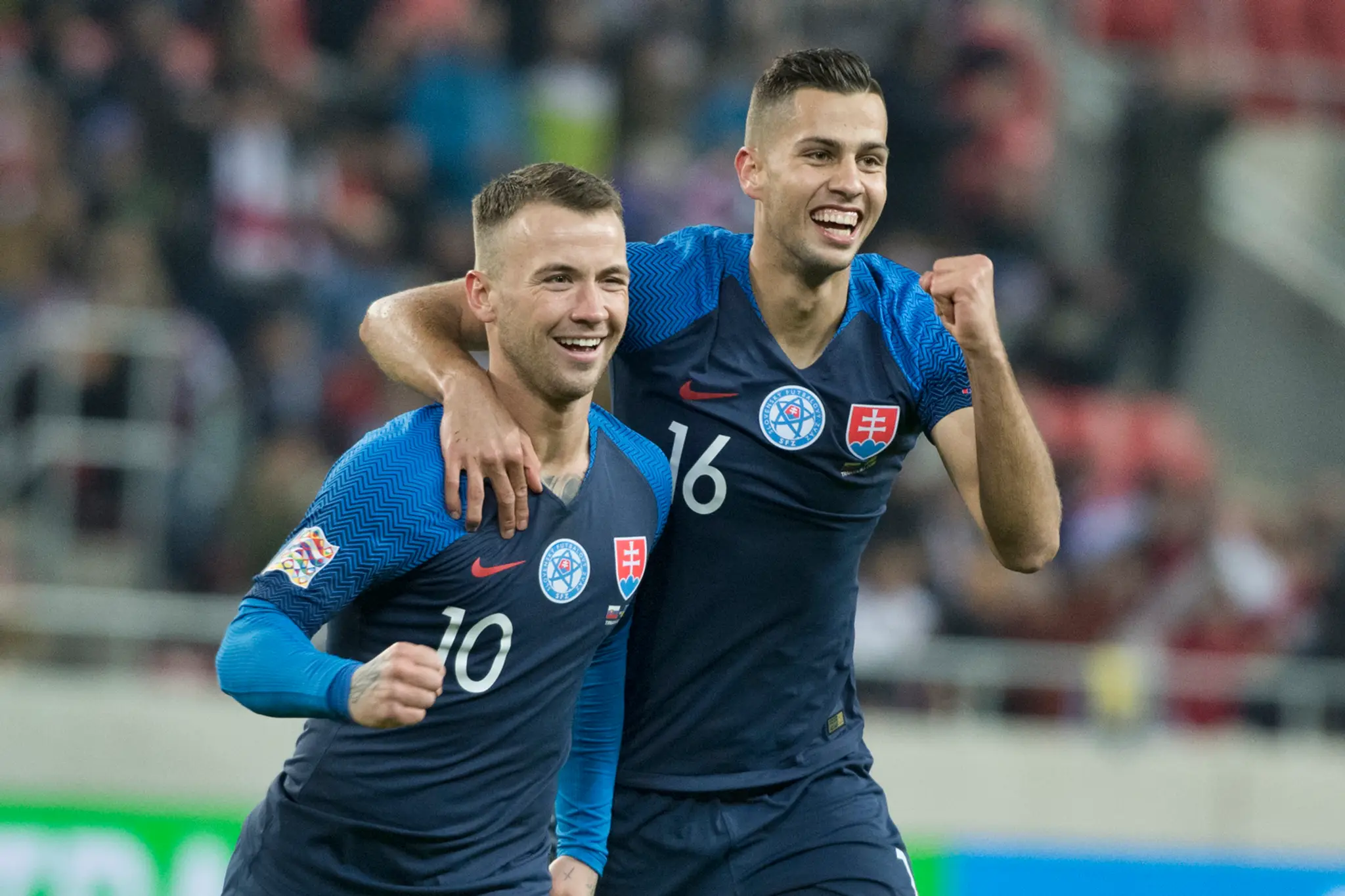 Slovenskí reprezentanti Albert Rusnák (vľavo) a Dávid Hancko oslavujú gól v dueli Ligy národov proti Ukrajine.