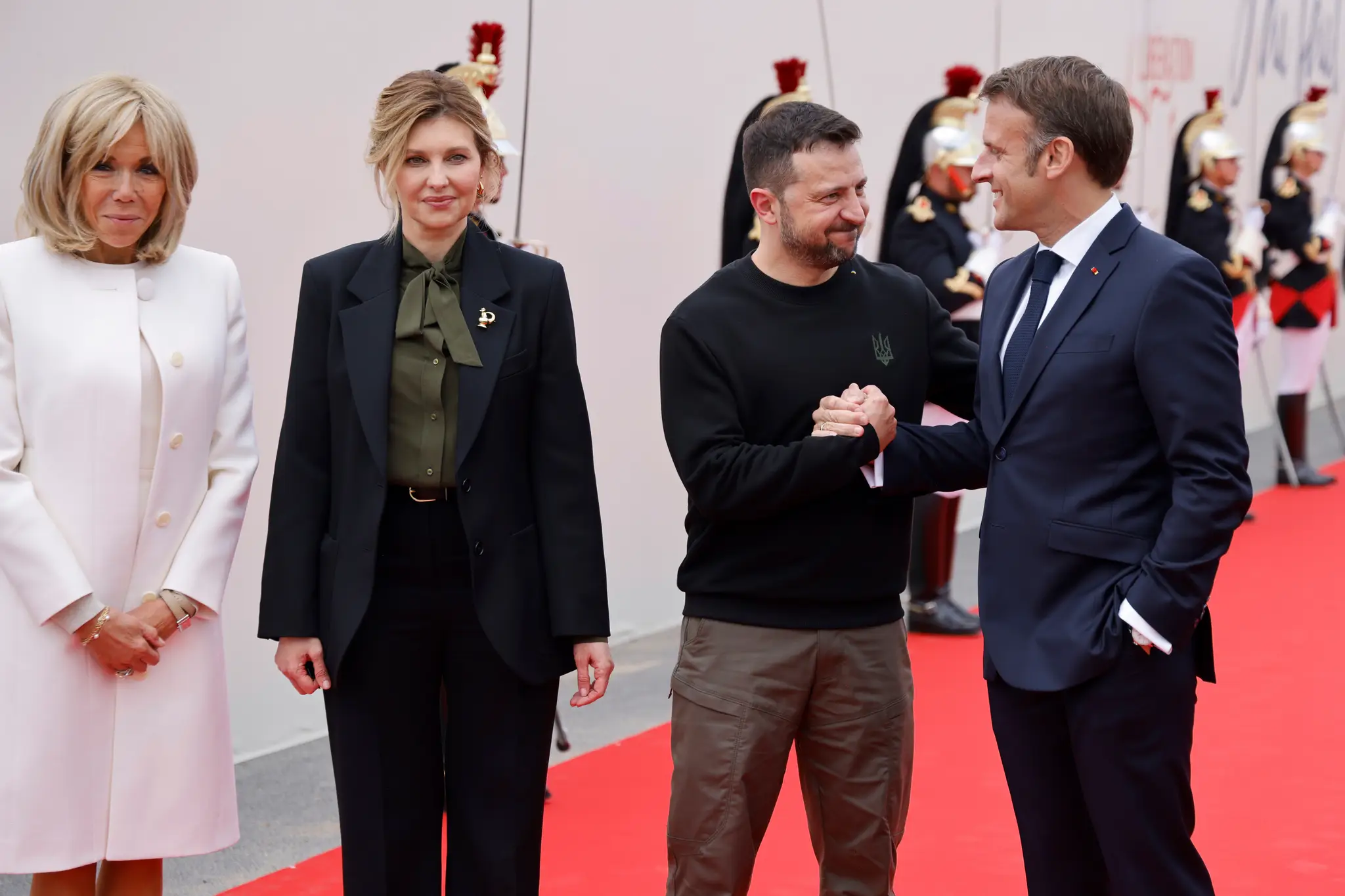 Francúzsky prezident Emmanuel Macron (vpravo) víta ukrajinského prezidenta Volodymyra Zelenského (druhý sprava) a Brigitte Macronová (vľavo) Olenu Zelenskú (druhá zľava).