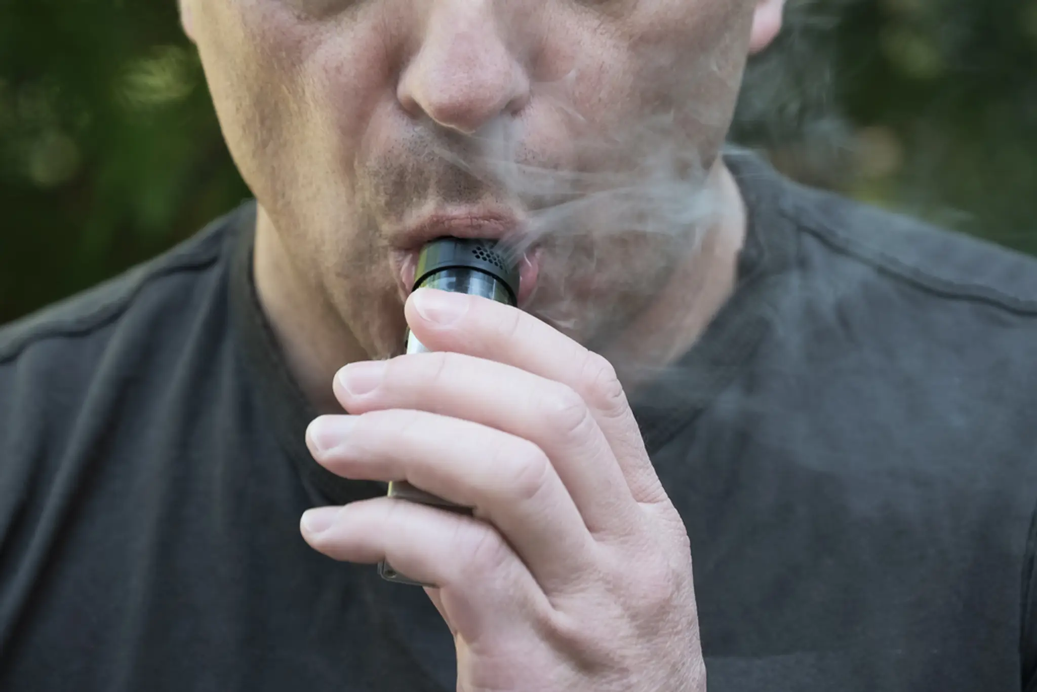 Muž fajčí elektronickú cigaretu.