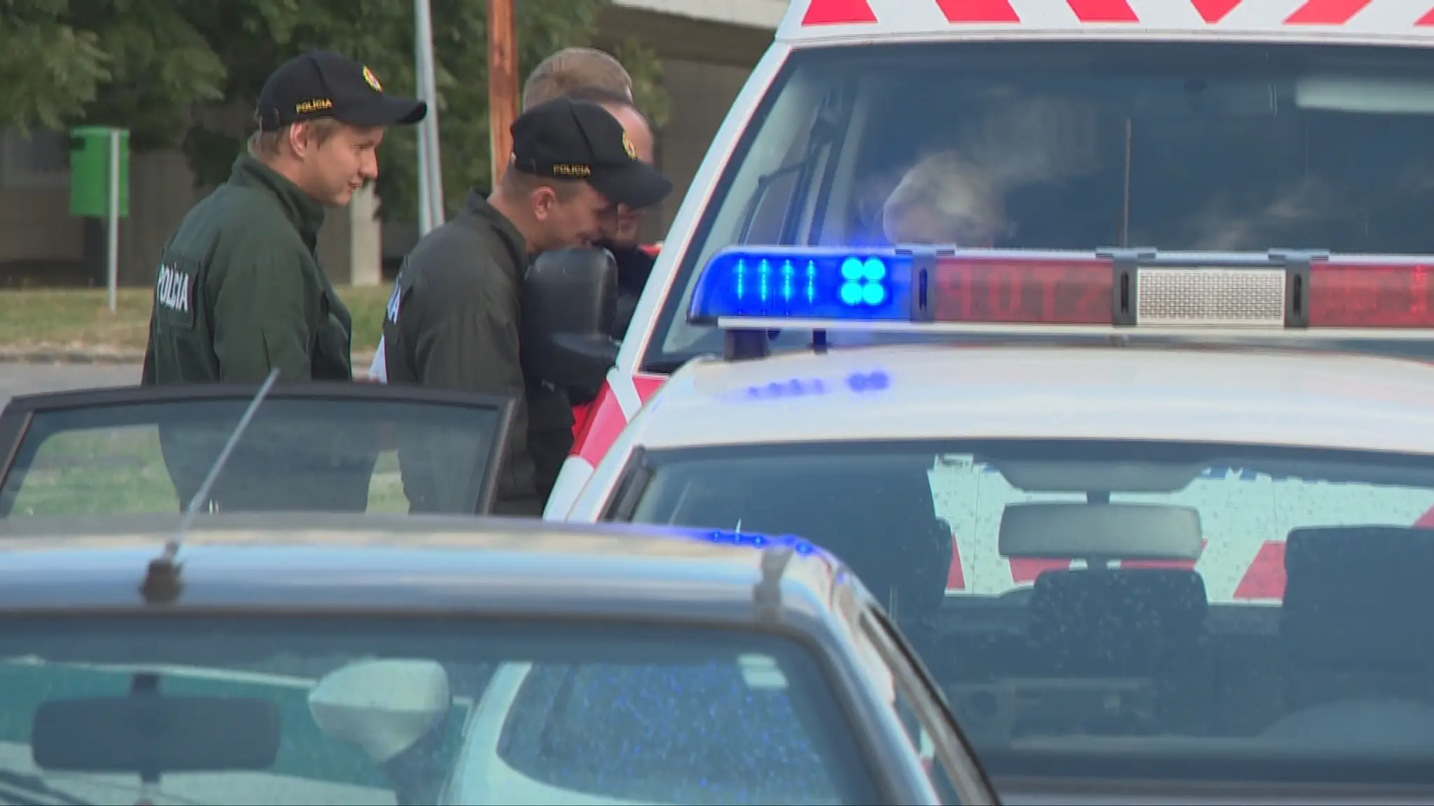 Obvinený muž v obklopení policajtov.