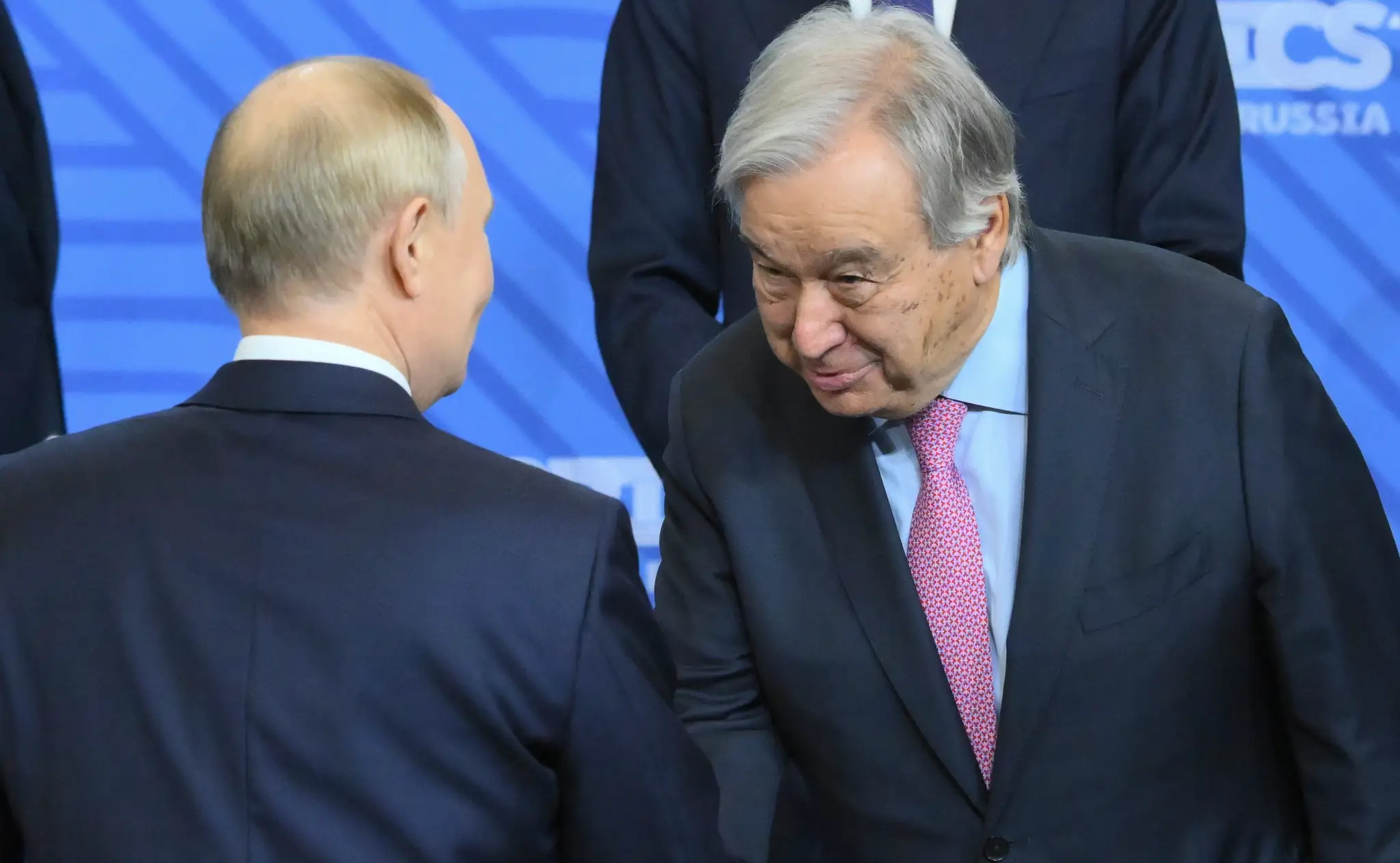 Ruský prezident Vladimir Putin (vľavo) a generálny tajomník OSN António Guterres si podávajú ruky pred summitom skupiny BRICS.