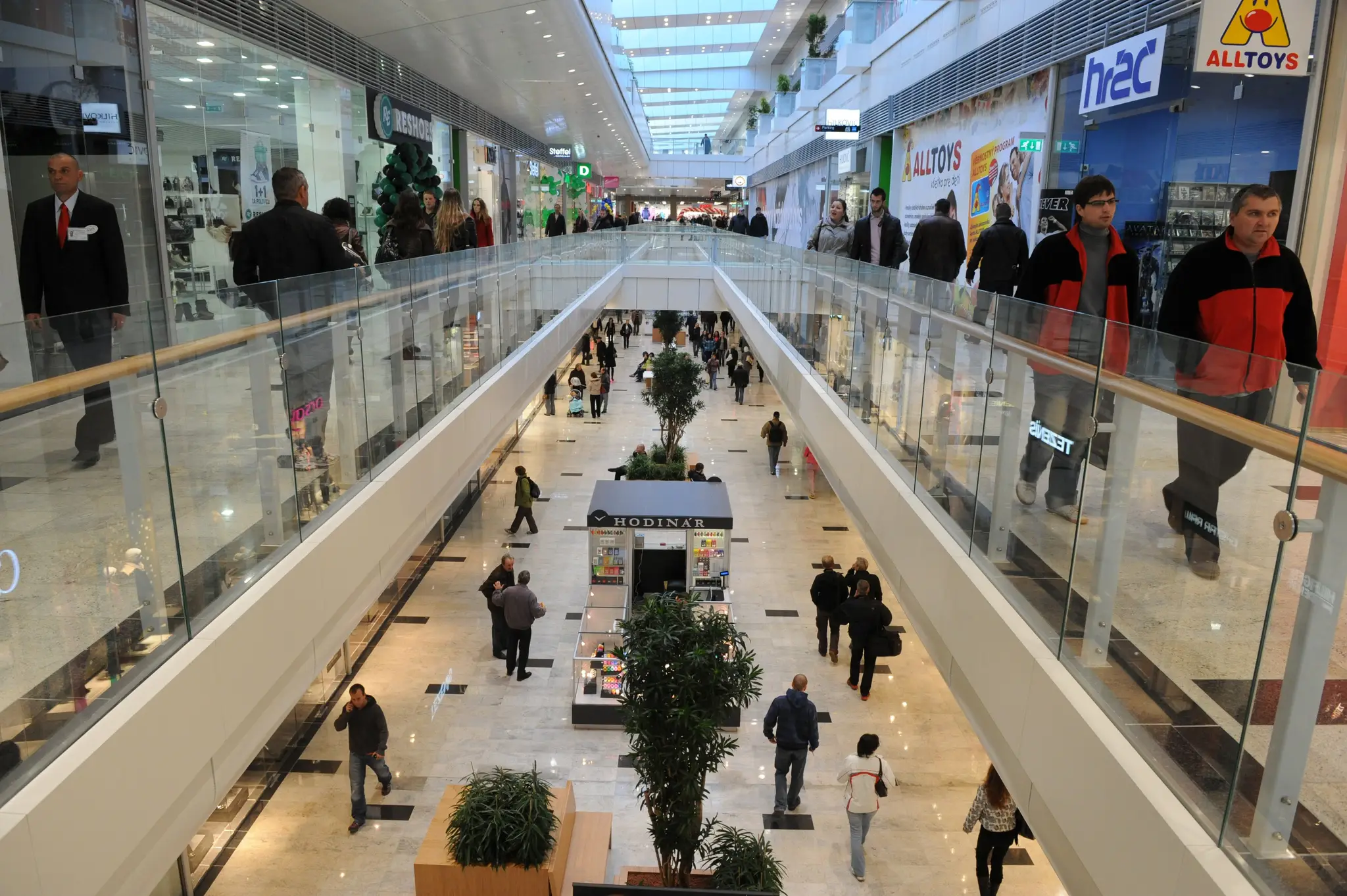 Snímka z obchodného centra, ľudia nakupujú, v rukách majú nákupné tašky.