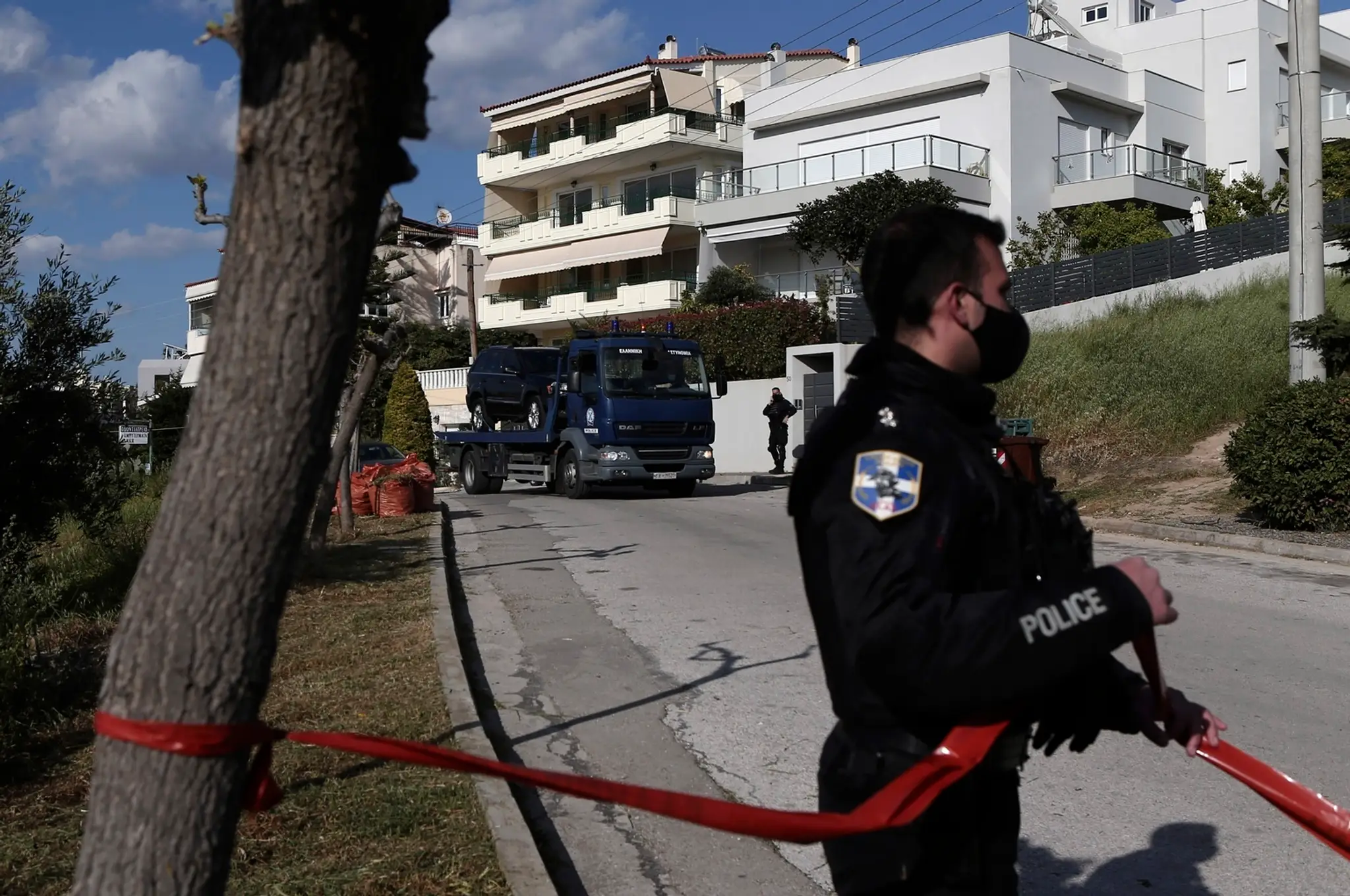 Policajti odvážajú auto známeho gréckeho novinára Jorgosa Karaivaza, ktorého zastrelili.