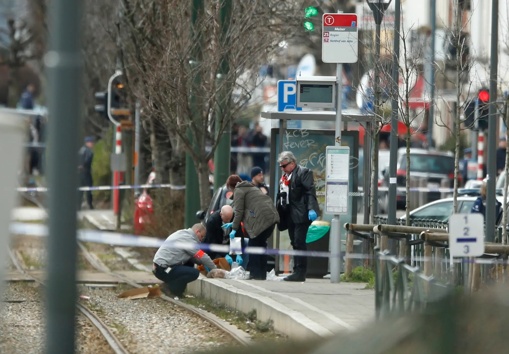 Policajní vyšetrovatelia zaisťujú stopy na električkovej zastávke počas policajnej akcie v belgickej štvrti Schaerbeek