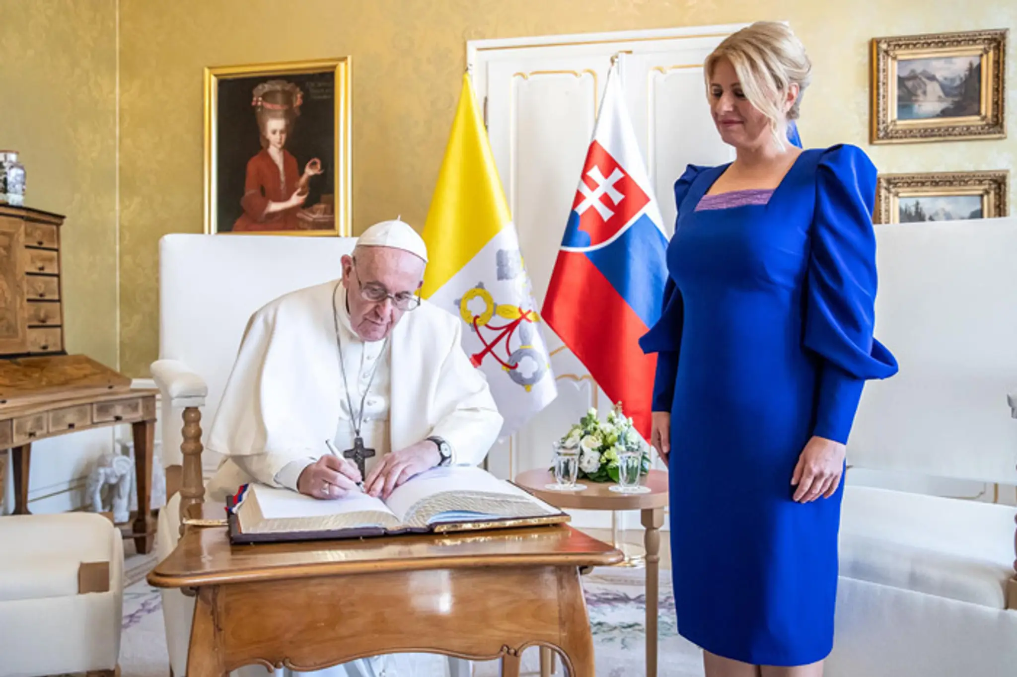 Pápež František sa podpisuje do prezidentskej knihy návštev.