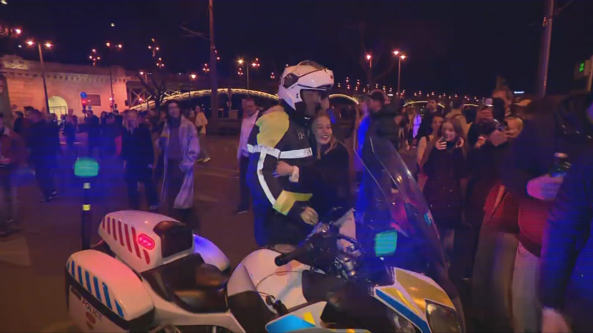 Policajt objíma ľudí.