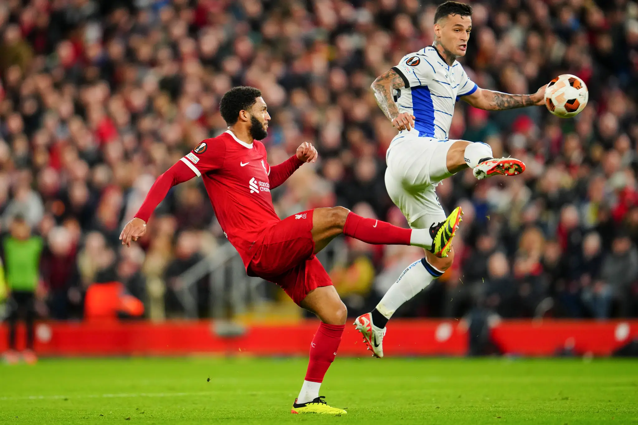 Futbalista Liverpoolu Joe Gomez (vľavo) a hráč Atalanty Gianluca Scamacca bojujú o loptu.
