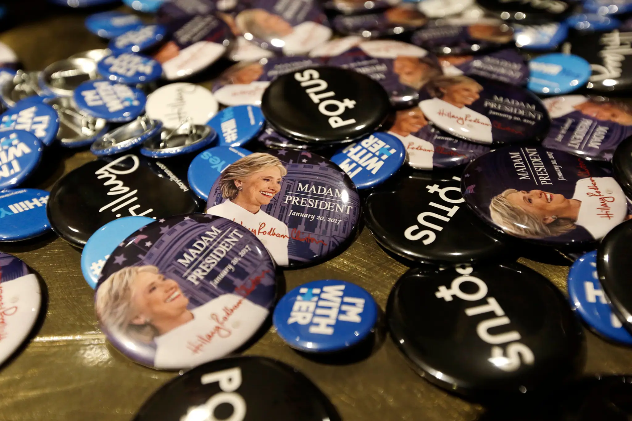 Odznaky propagujúce prezidentskú kandidátku Hillary Clintonovú.