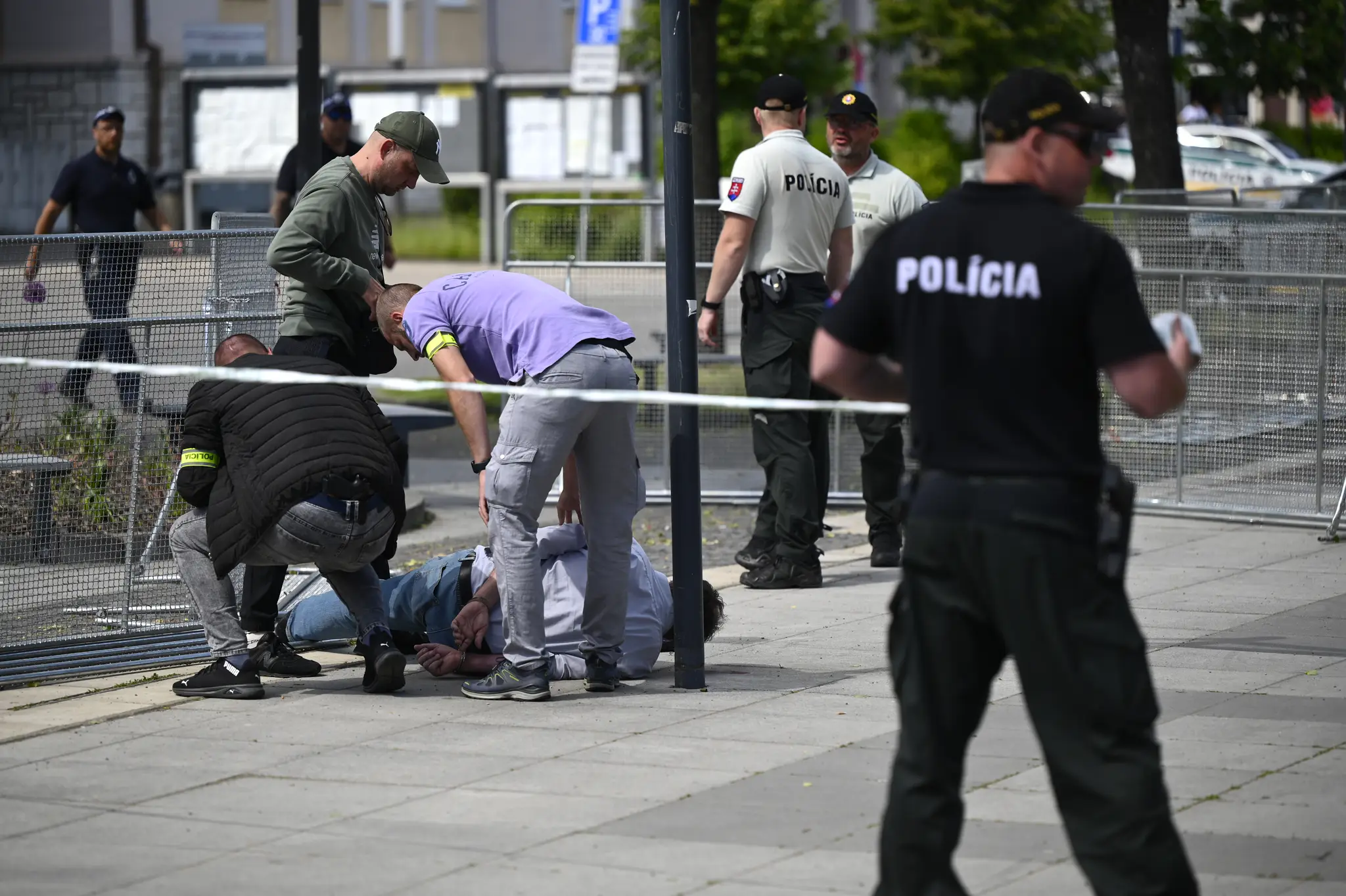 Na snímke policajti zatýkajú muža po streľbe na predsedu vlády Roberta Fica na výjazdovom rokovaní vlády v Handlovej.