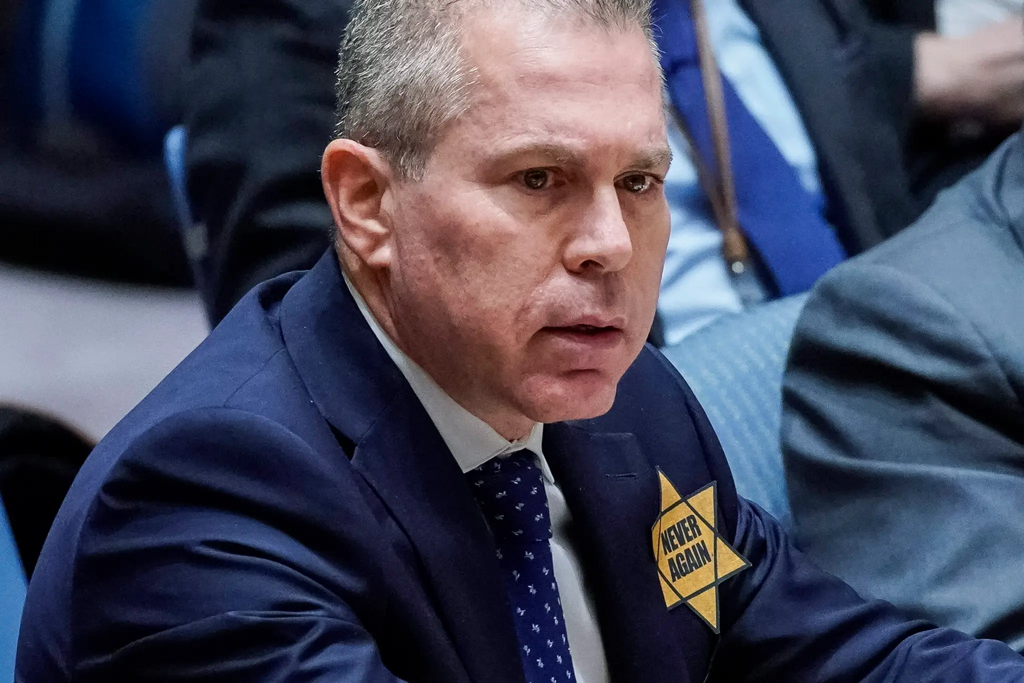 Na snímke Gilad Erdan, ktorý si pripol na chlopňu svojho saka Dávidovu hviezdu s nápisom "Nikdy viac".