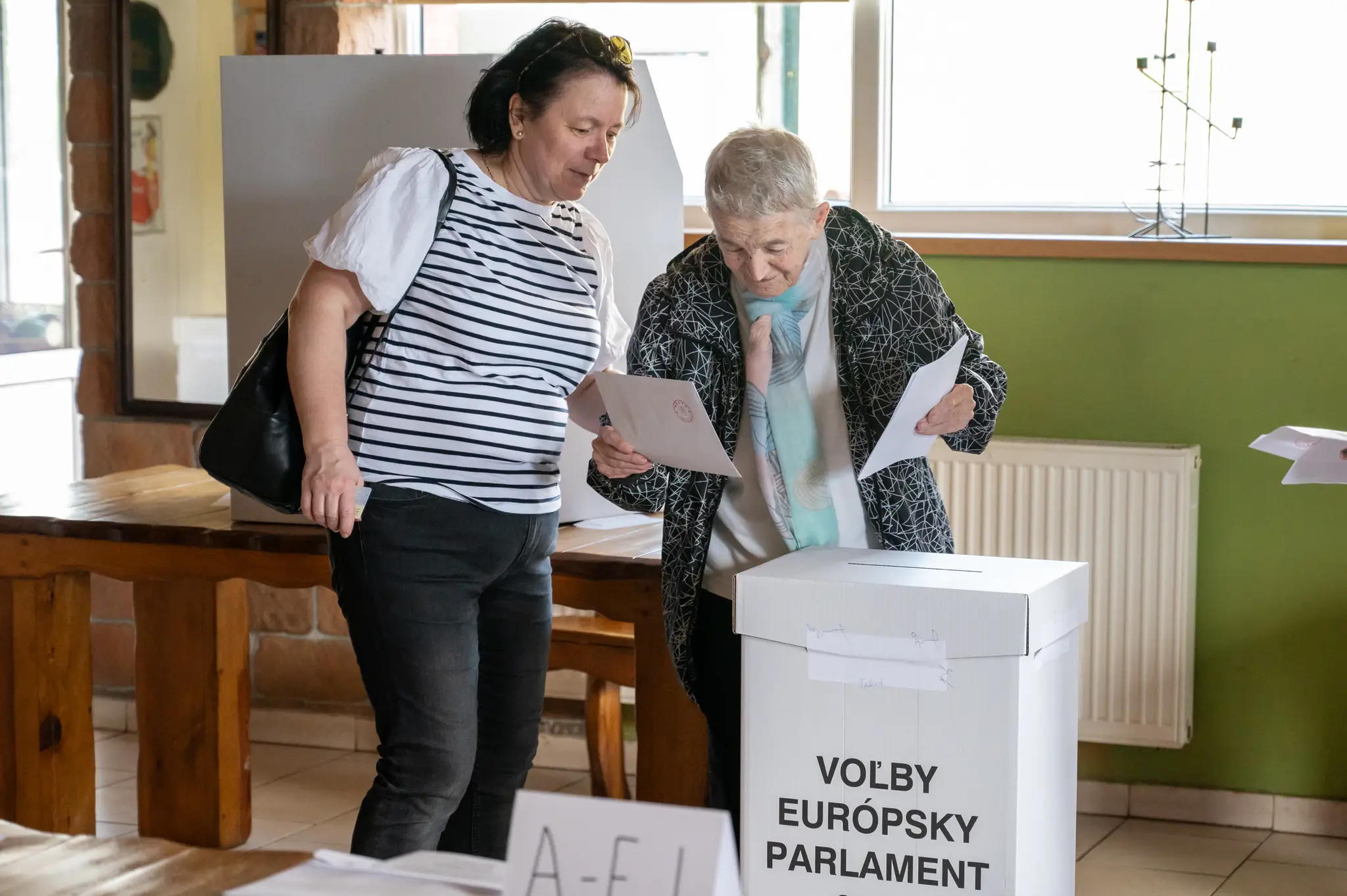 Na snímke volička s doprovodom vhadzuje obálku s hlasovacím lístkom do volebnej schránky v Prešove.