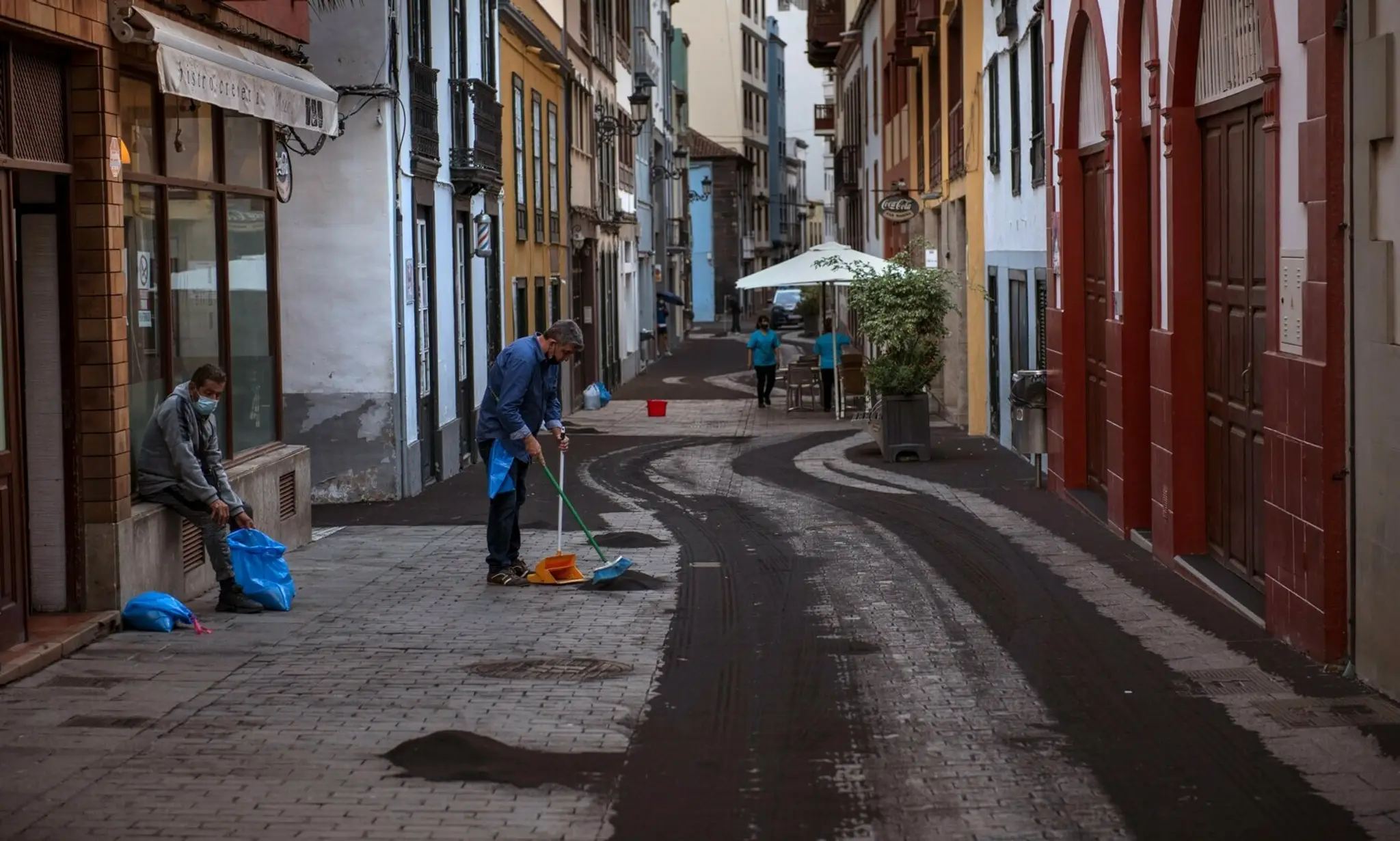 Obyvatelia čistia ulicu od popola zo sopky La Cumbre Vieja na španielskom ostrove La Palma.