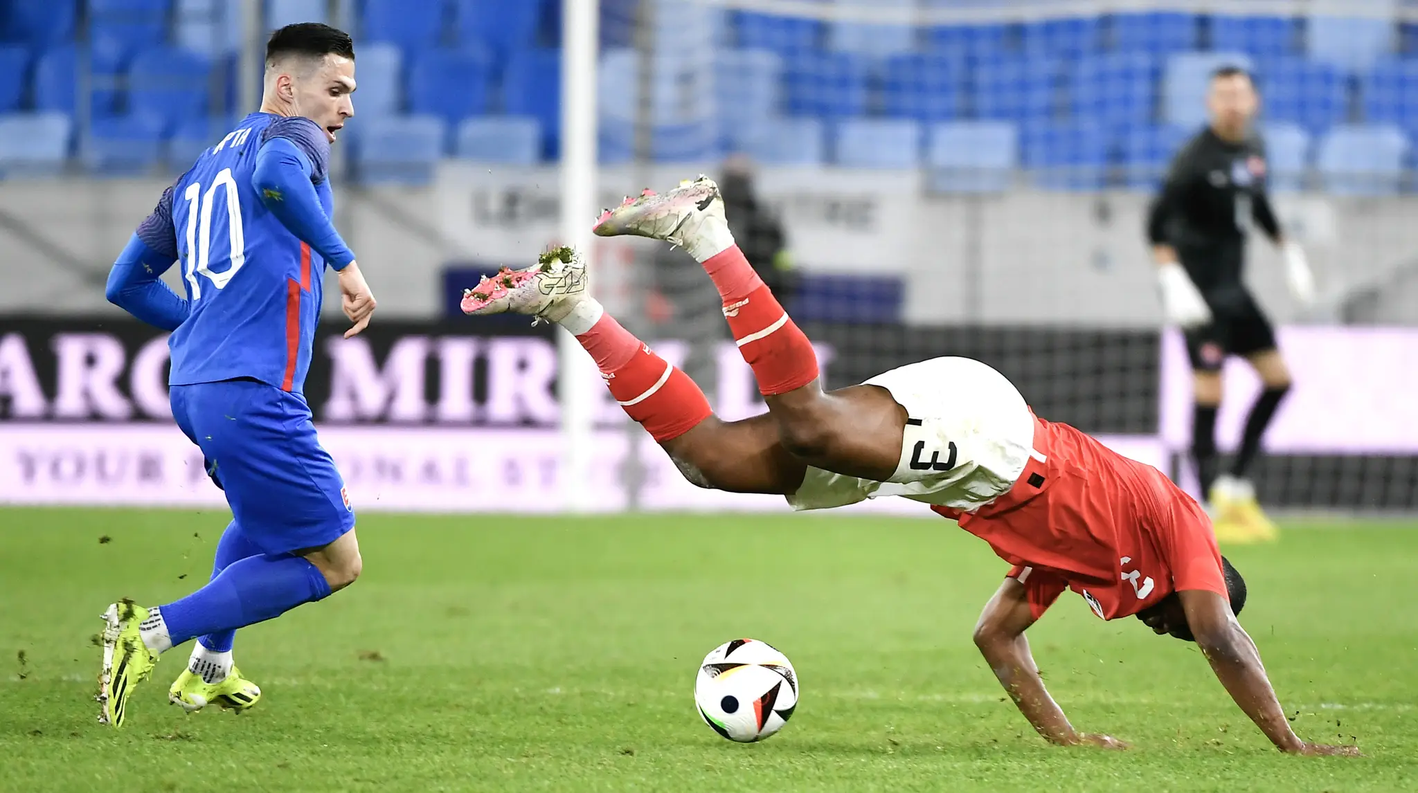 Ľubomír Tupta (Slovensko) a vpravo Kevin Danso (Rakúsko) bojujú o loptu počas prípravného medzištátneho futbalového stretnutia