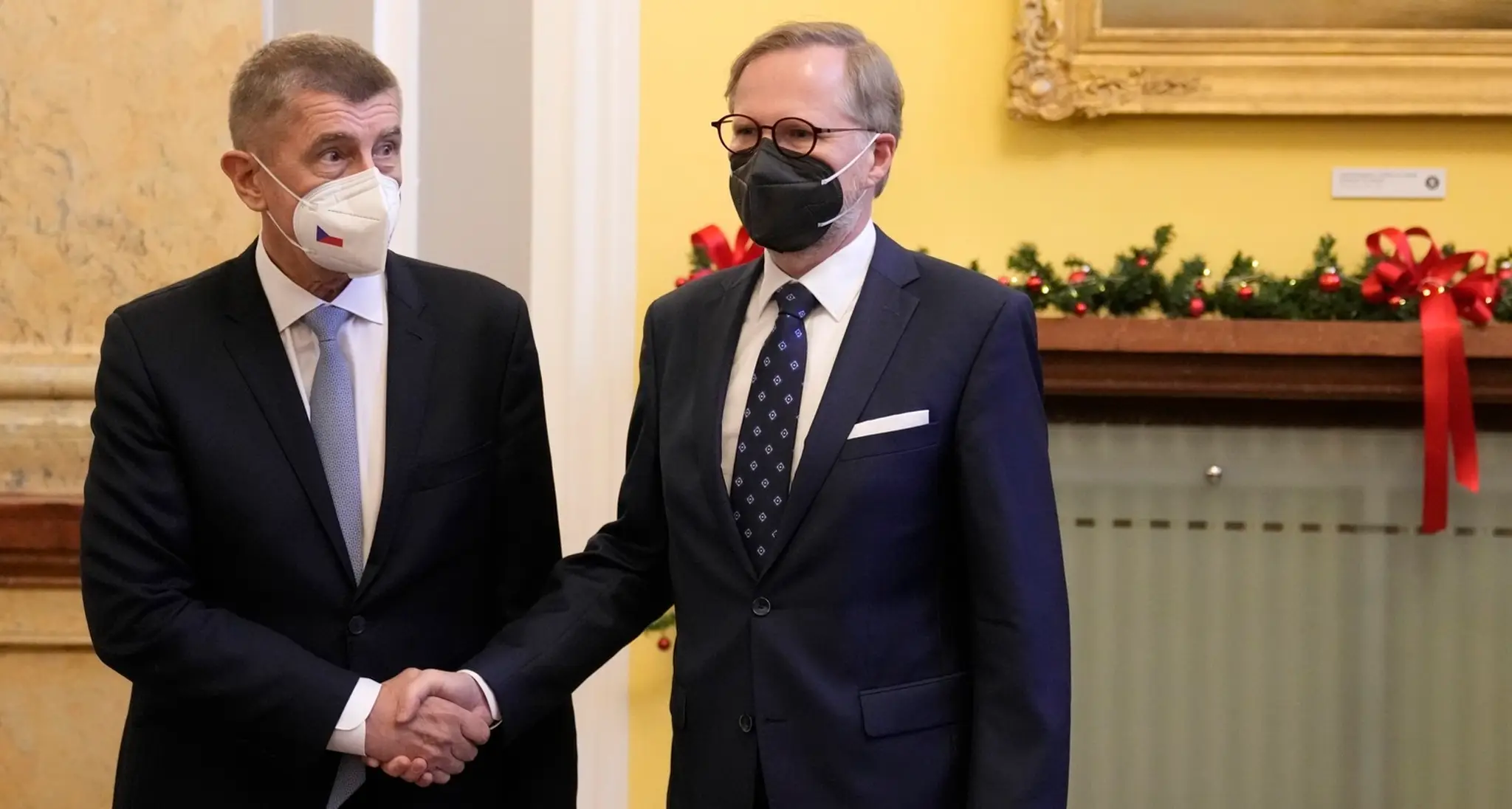 Odchádzajúci český premiér Andrej Babiš (vľavo) a nový český premiér Petr Fiala sa vítajú na úrade vlády v Prahe.