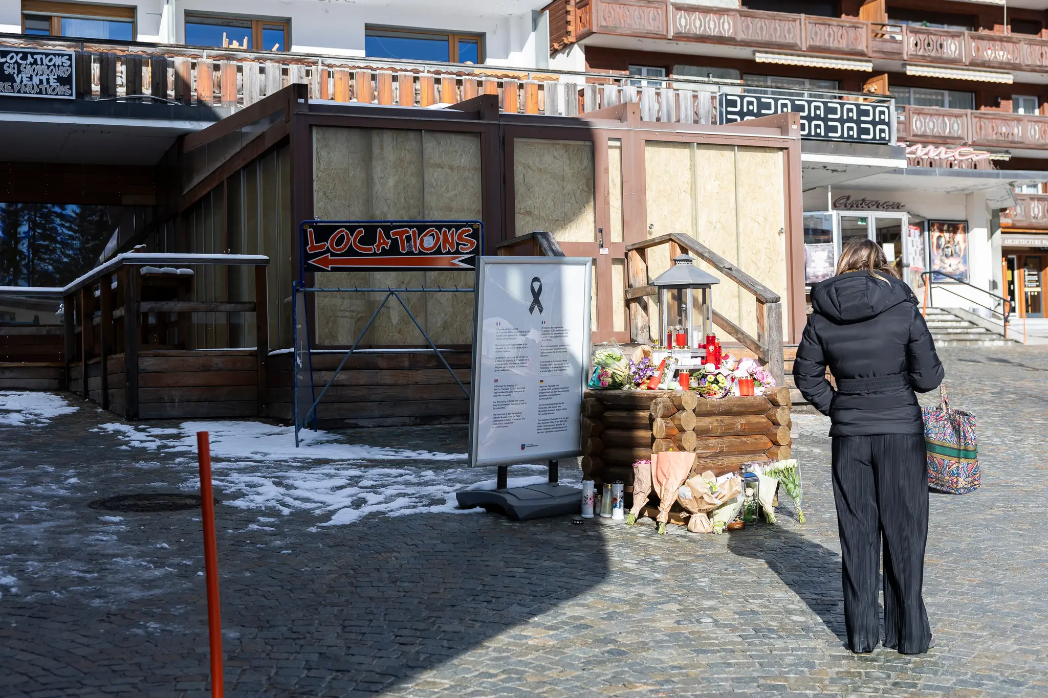 Žena stojí pred barom v luxusnom švajčiarskom lyžiarskom stredisku Crans Montana, kde pri novoročnom požiari zahynulo 40 ľudí.