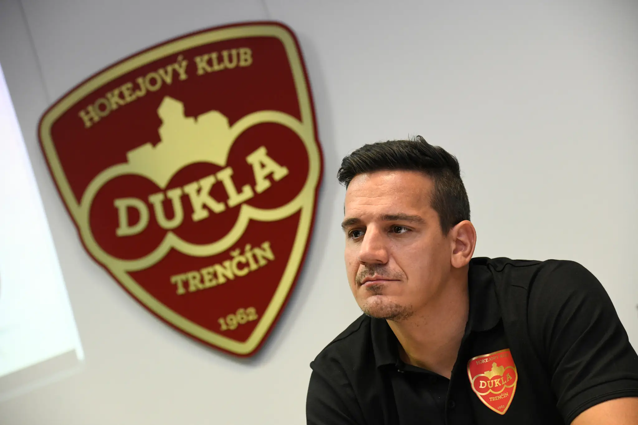 Kapitán Dukly Trenčín Branko Radivojevič a v pozadí nové logo klubu.
