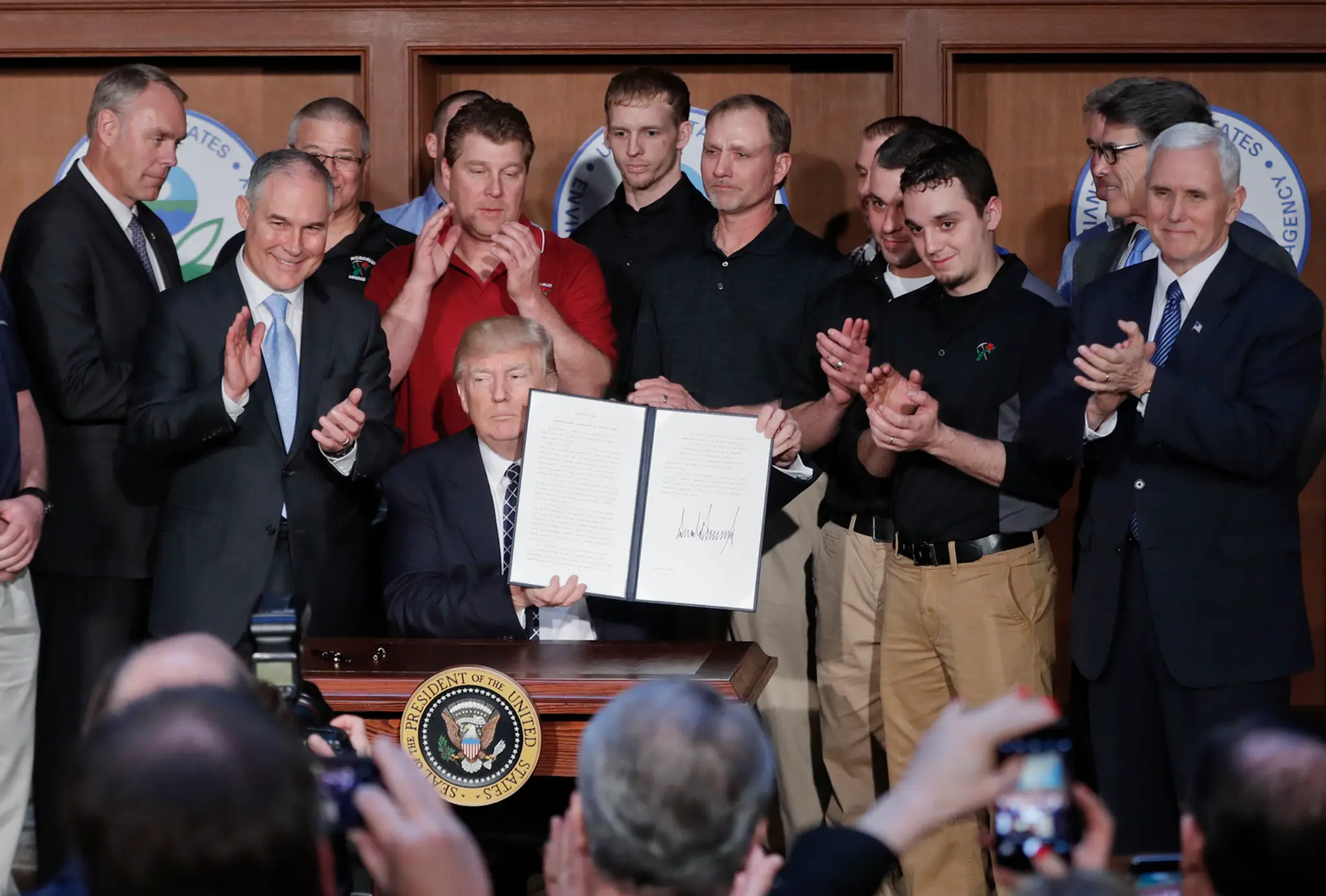 Americký prezident Donald Trump drží podpísaný dekrét.