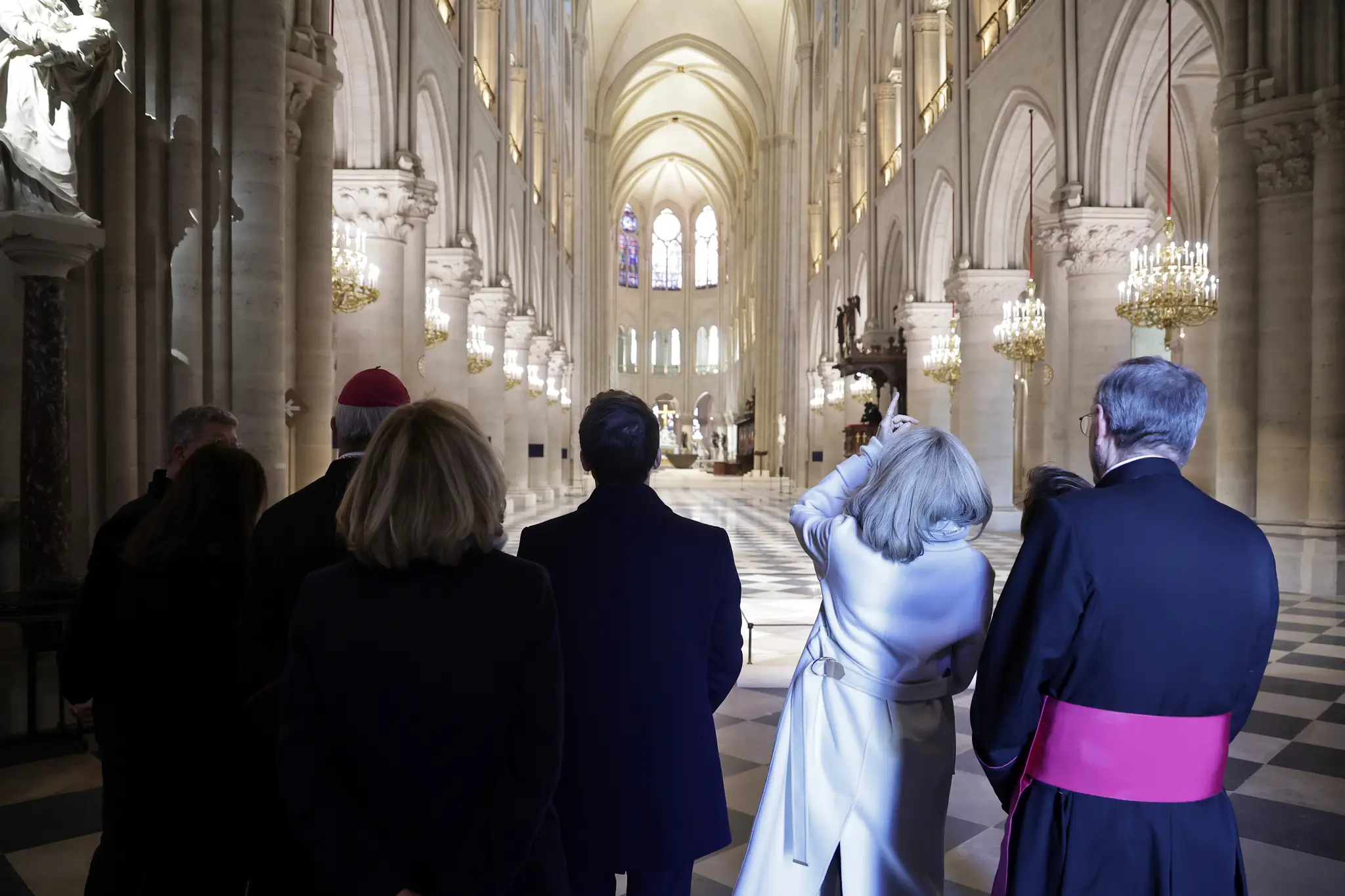 Na snímke francúzsky prezident Emmanuel Macron (tretí sprava) a prvá dáma Francúzska  Brigitte Macronová (druhá sprava), ktorí navštívili zrekonštruovanú parížsku katedrálu Notre- Dame