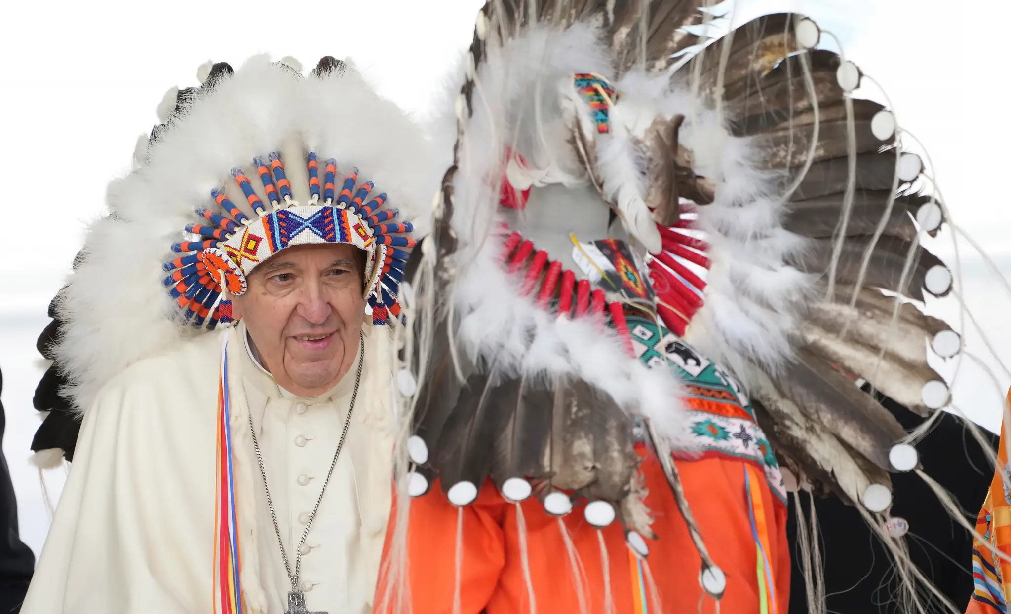 Pápež František (vľavo) má na hlave tradičnú čelenku, ktorú dostal po ospravedlnení sa pôvodným obyvateľom počas obradu v meste Maskwacis v provincii Alberta.