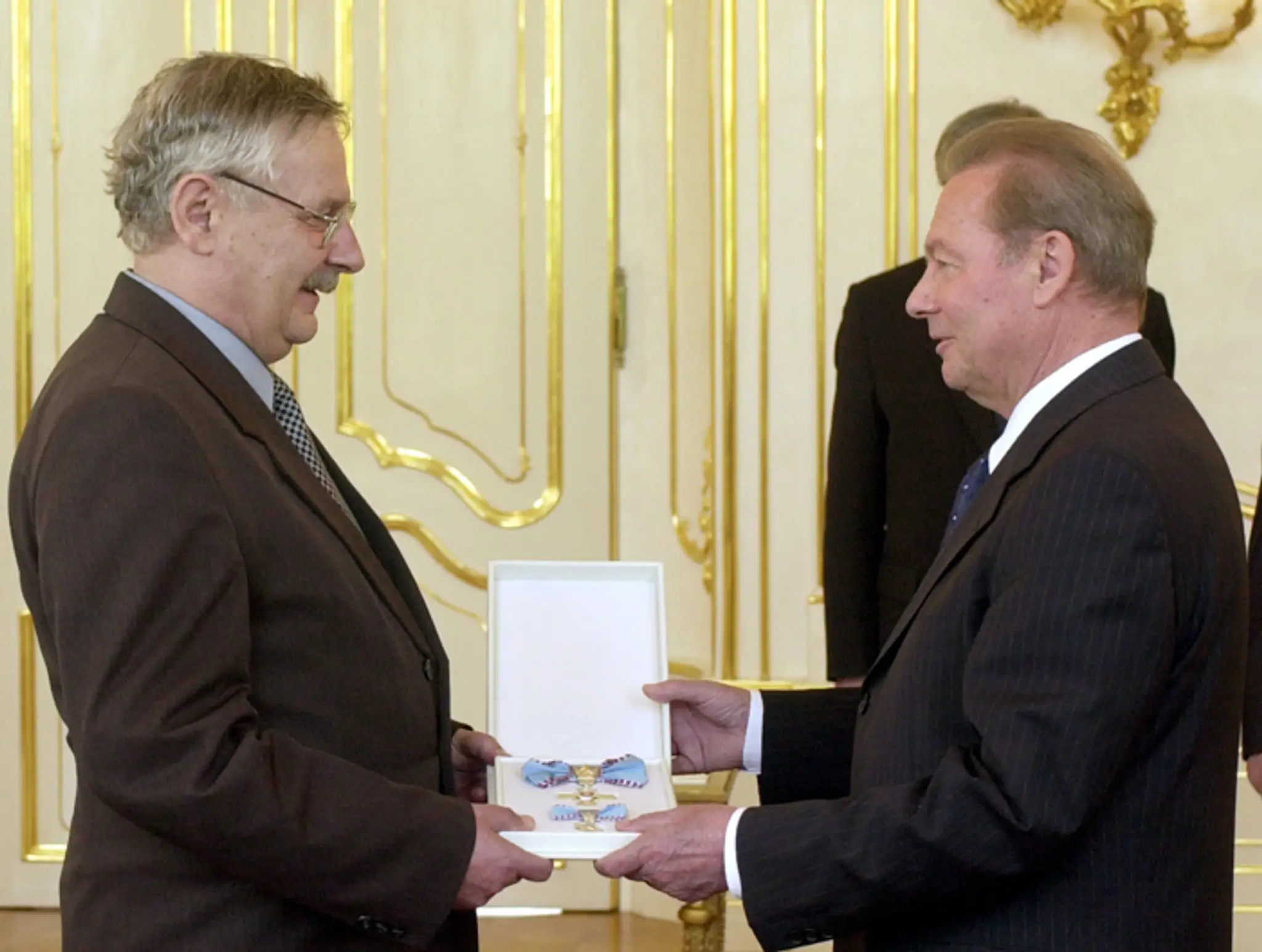 Juraj Slezáček preberá 1. júna 2004  z rúk prezidenta Rudolfa Schustera ocenenie Kríž prezidenta SR II. stupňa.
