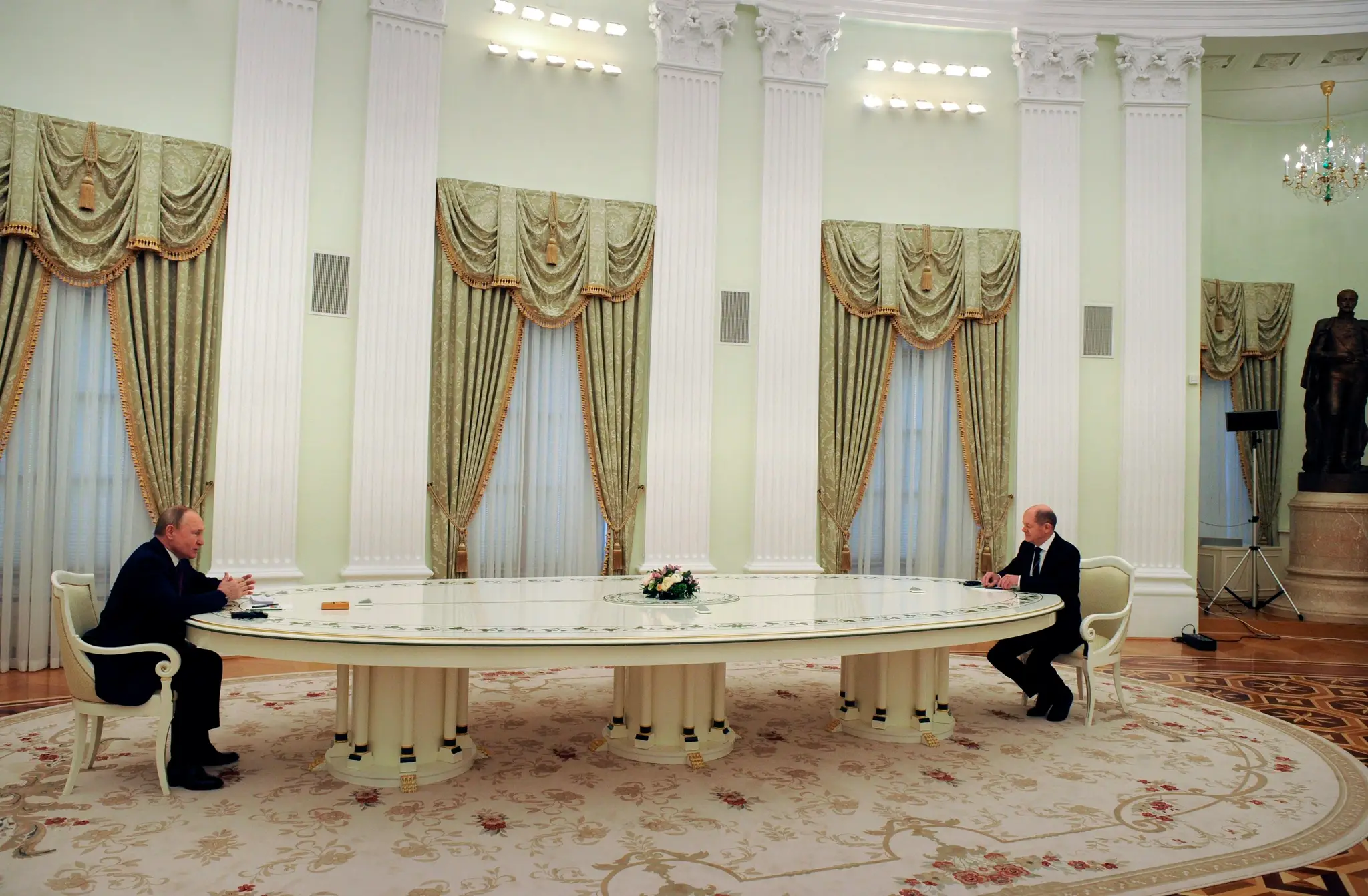 Nemecký kancelár Olaf Scholz a ruský prezident Vladimir Putin sedia na opačných koncoch stola počas rokovania v Moskve, ktorého cieľom bolo zmiernenie napätia medzi Západom a Ruskom.