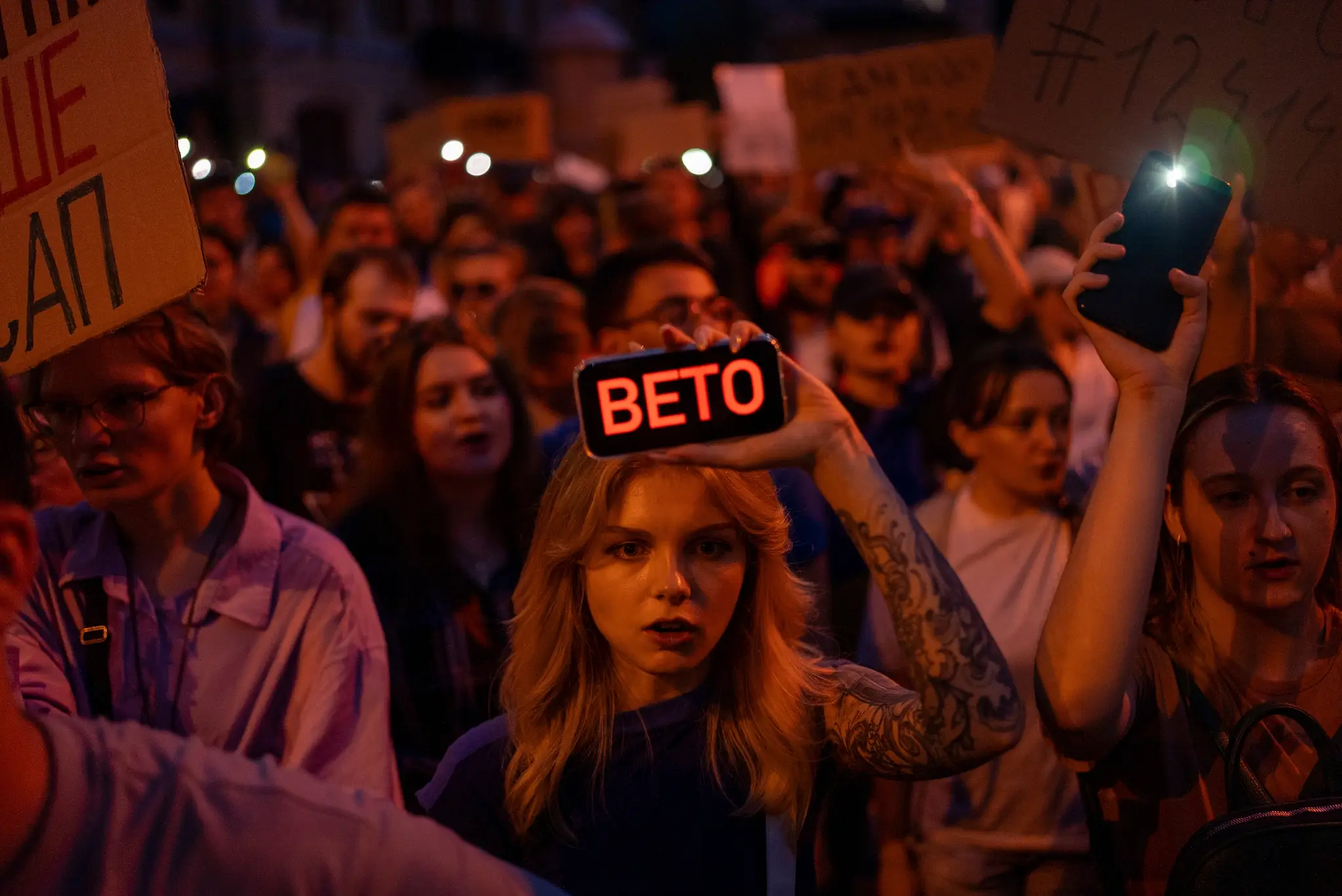 Demonštrantka drží transparent s nápisom Veto počas protestu proti zákonu obmedzujúcemu autonómiu protikorupčných úradov v Kyjeve.
