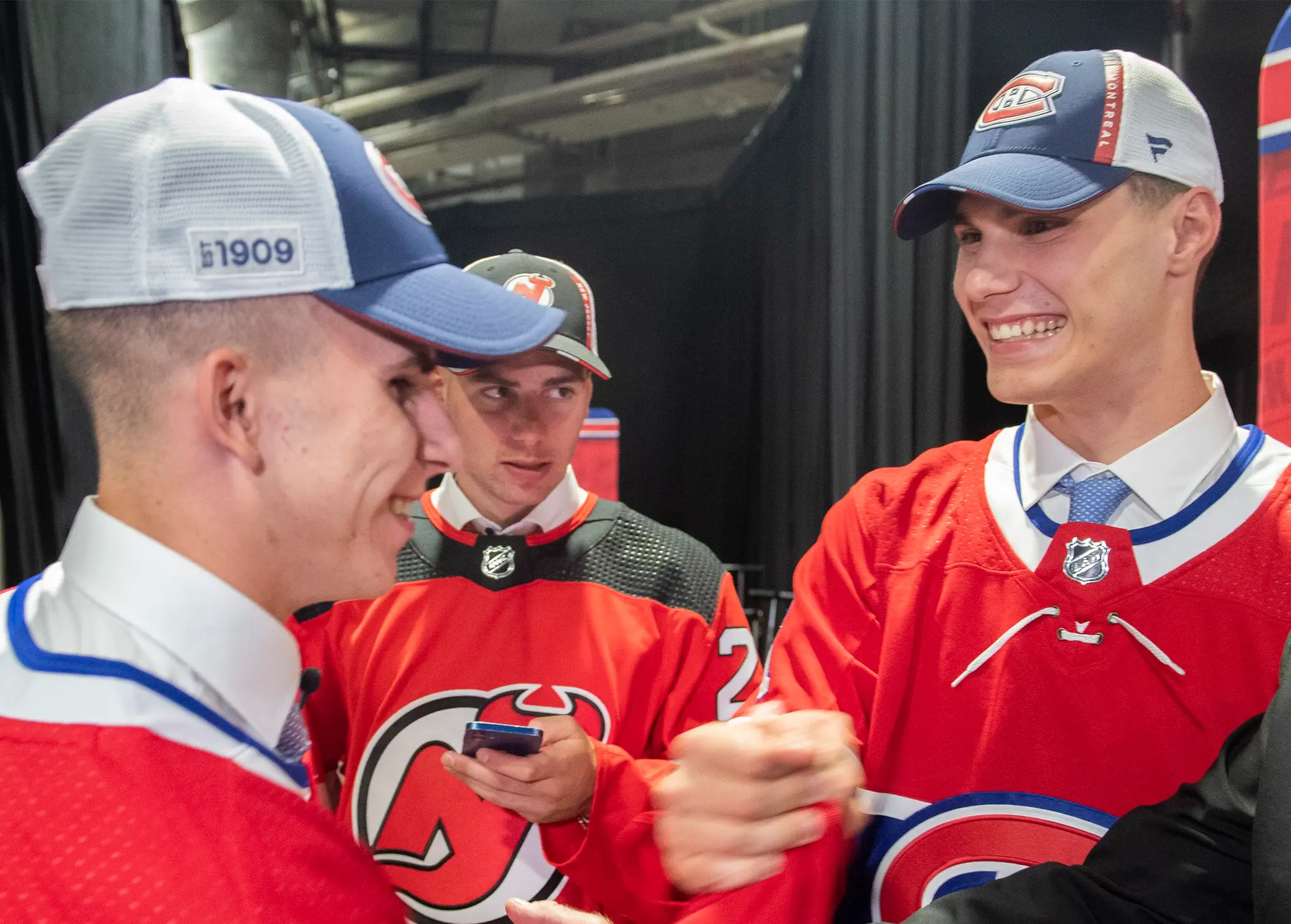 Zľava Filip Mešár, Šimon Nemec a Juraj Slafkovský po 1. kole draftu NHL 2022.