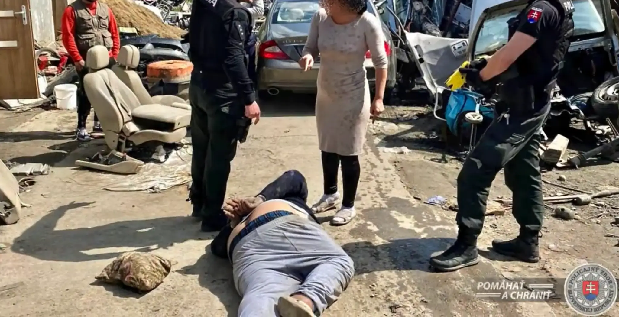Na snímke je záver policajnej naháňačky. Muž leží na zemi s putami na rukách, v okolí stoja policajti aj žena. 