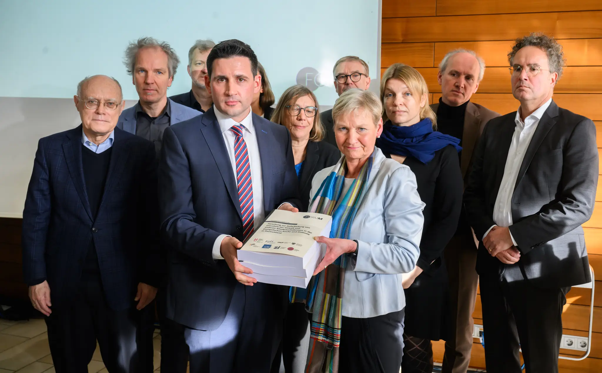 Martin Wazlawik, koordinátor výskumnej siete "ForuM", odovzdáva na tlačovej konferencii úradujúcej predsedníčke Rady Evanjelickej cirkvi v Nemecku (EKD) Kirsten Fehrsovej štúdiu o zneužívaní v protestantskej cirkvi.